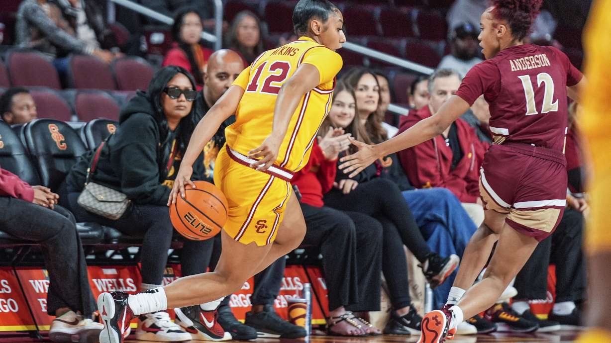 Southern California guard JuJu Watkins, left, dribbles against Elon guard Laila Anderson, right, during the first half of an NCAA college basketball game in Los Angeles Sunday, Dec. 15, 2024.