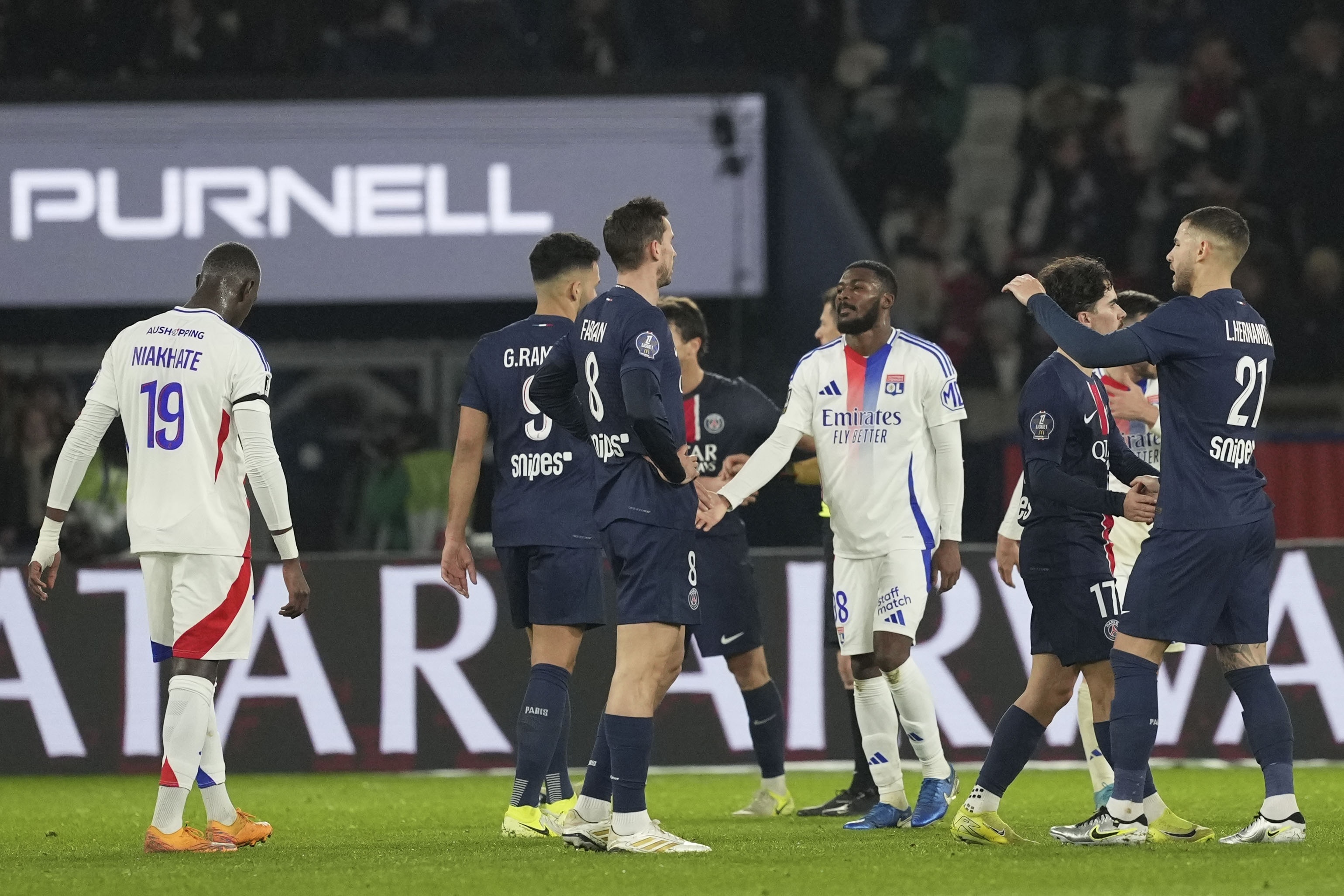 Lyon's Ainsley Maitland-Niles, center, and Lyon's Moussa Niakhate react at the end of the French League One soccer match between Paris Saint-Germain and Lyon at the Parc des Princes in Paris, Sunday, Dec. 15, 2024.
