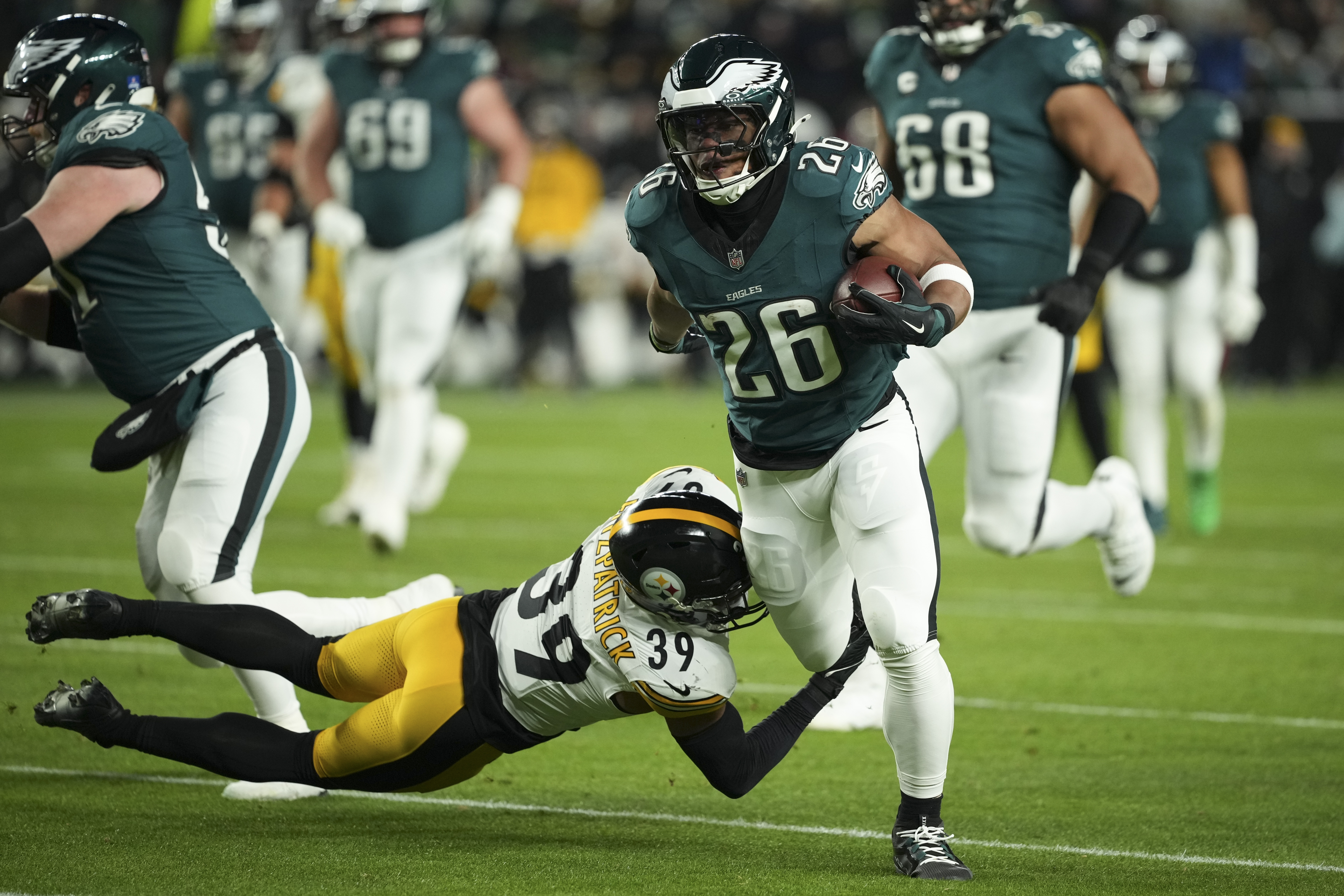 Philadelphia Eagles running back Saquon Barkley (26) runs with the ball as Pittsburgh Steelers safety Minkah Fitzpatrick (39) tries to stop him during the first half of an NFL football game Sunday, Dec. 15, 2024, in Philadelphia. 