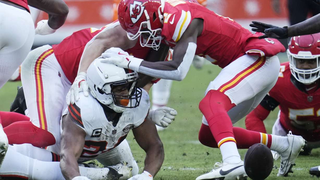 Cleveland Browns running back Nick Chubb, left, watches the ball after his fumble in the second half of an NFL football game against the Kansas City Chiefs in Cleveland, Sunday, Dec. 15, 2024. Chiefs' Joshua Williams (2) has his hand on Chubb's helmet.