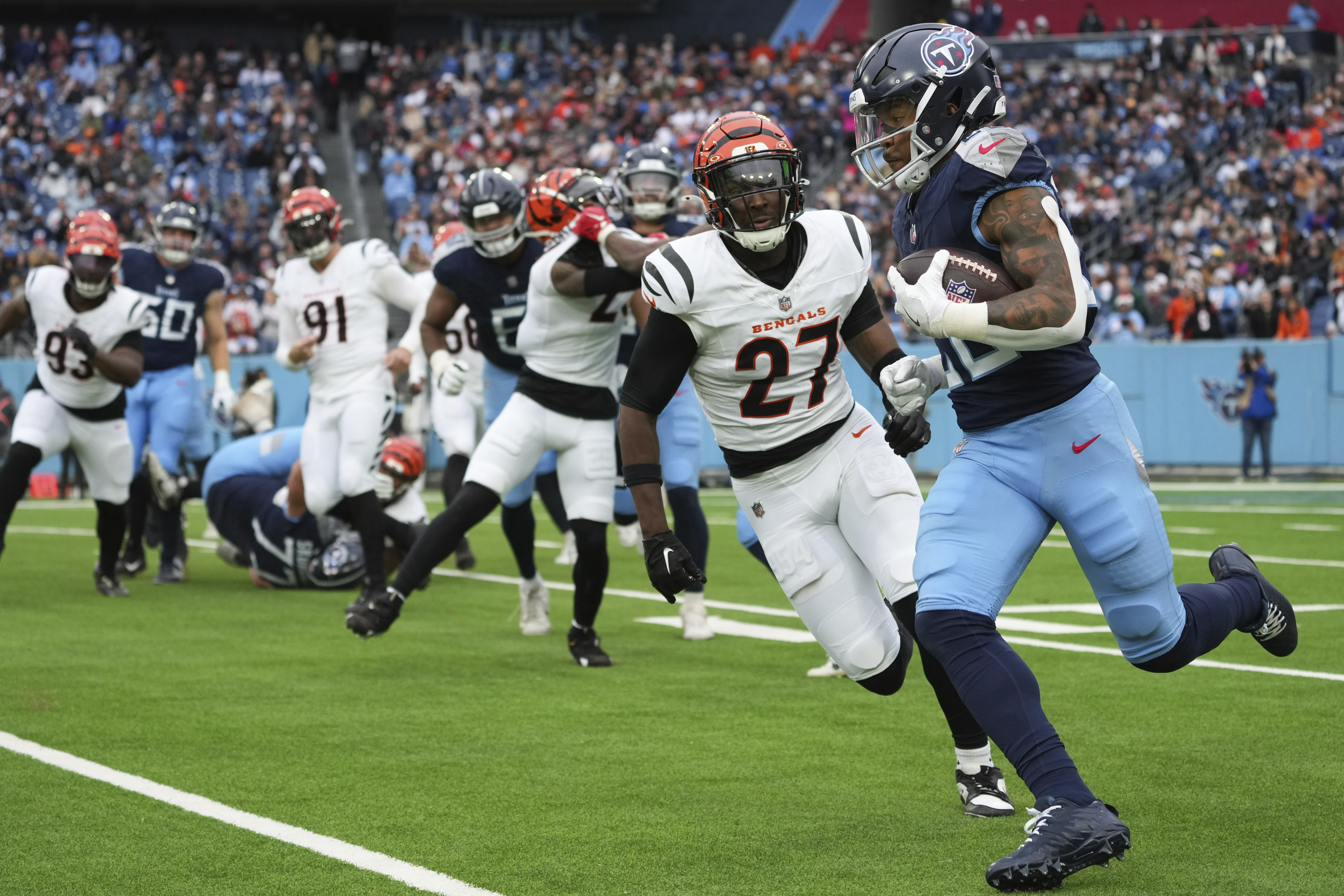 Tennessee Titans running back Tony Pollard (20) runs the ball past Cincinnati Bengals safety Jordan Battle (27) during the second half of an NFL football game Sunday, Dec. 15, 2024, in Nashville, Tenn.