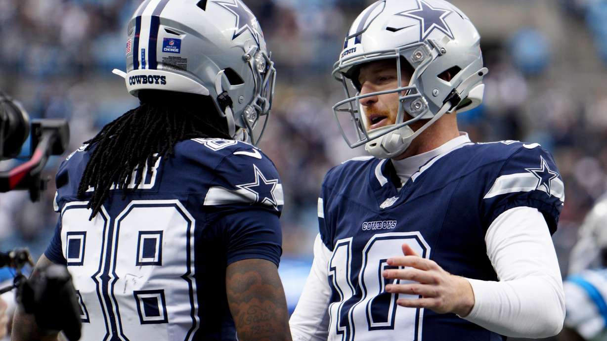 Dallas Cowboys wide receiver CeeDee Lamb celebrates after scoring with quarterback Cooper Rush against the Carolina Panthers during the first half of an NFL football game, Sunday, Dec. 15, 2024, in Charlotte, N.C.