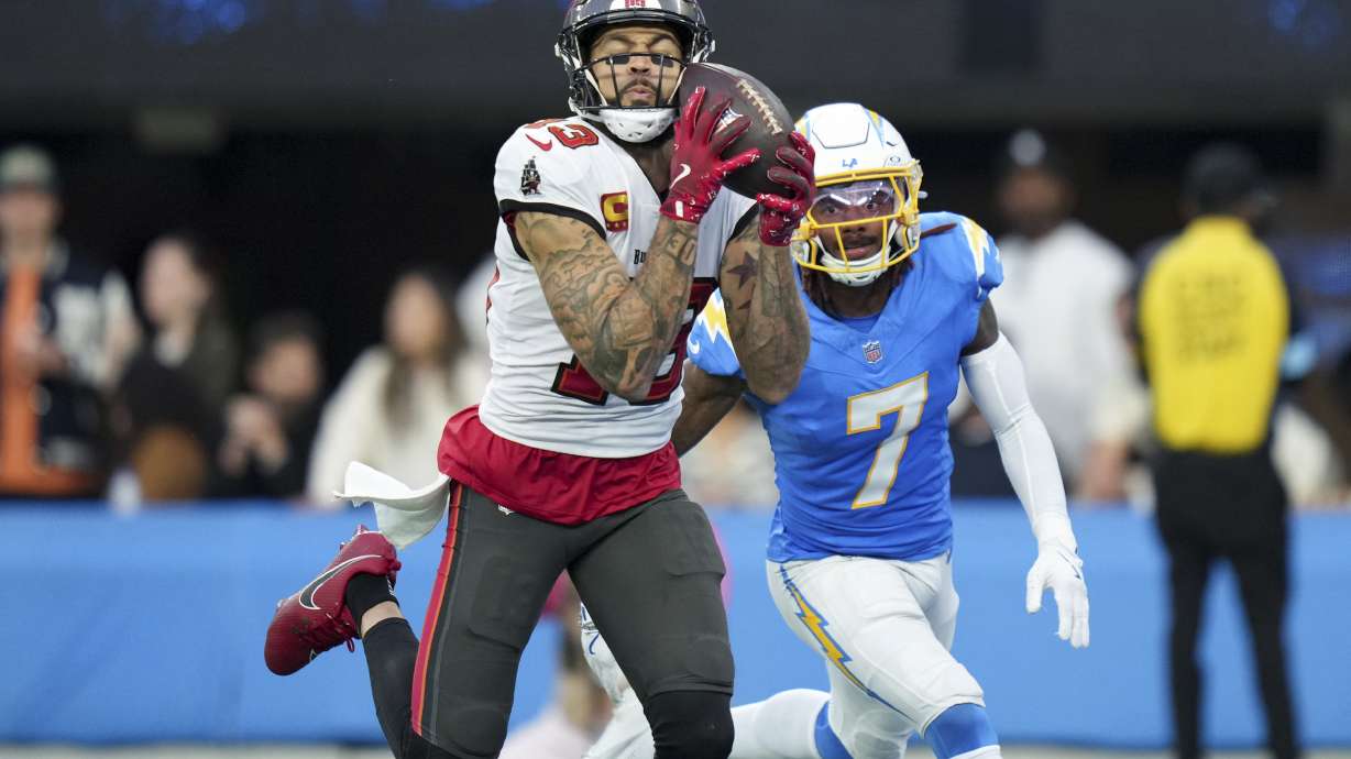 Tampa Bay Buccaneers wide receiver Mike Evans, left, catches a touchdown past Los Angeles Chargers cornerback Kristian Fulton (7) of an NFL football game Sunday, Dec. 15, 2024, in Inglewood, Calif. .