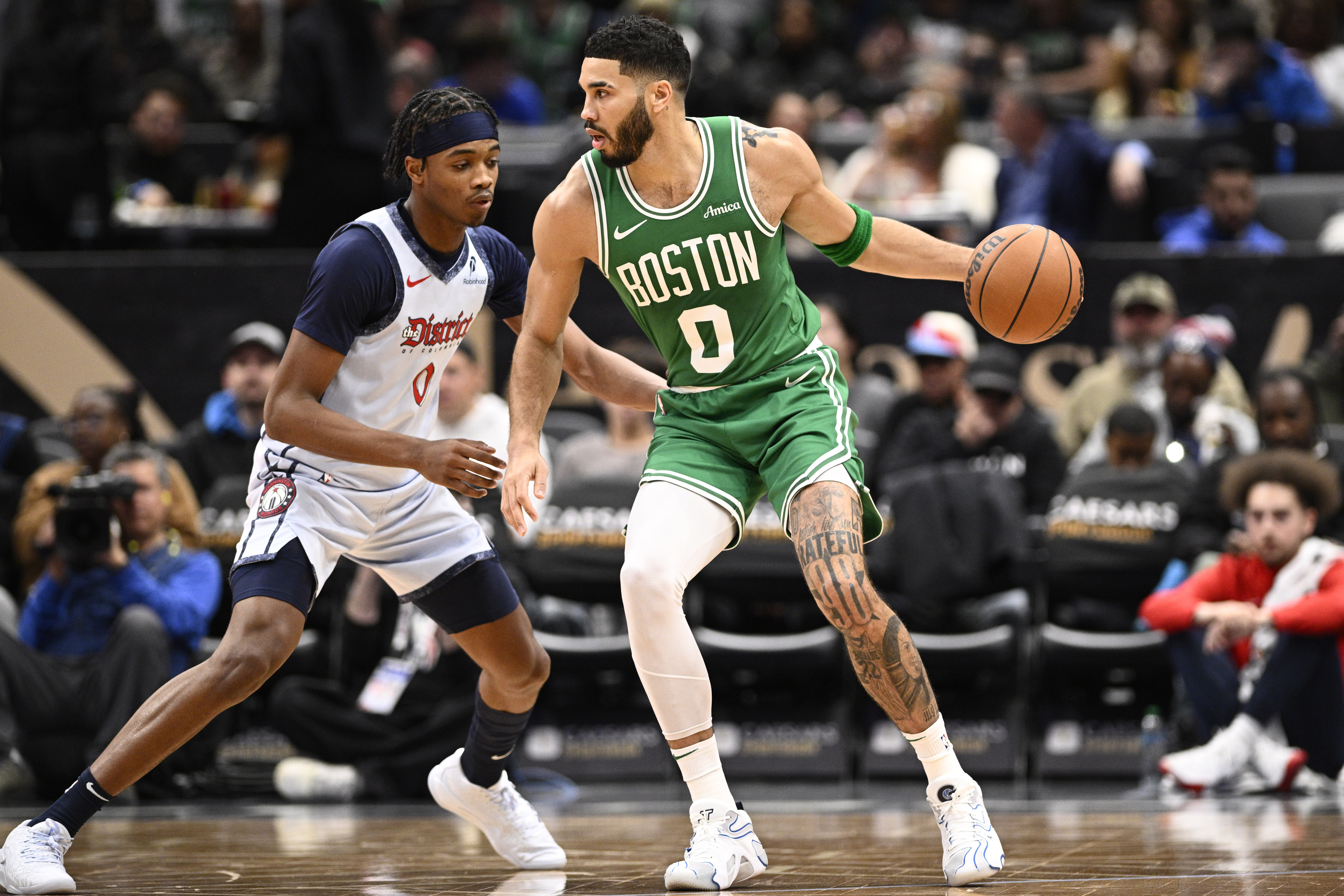 Boston Celtics forward Jayson Tatum, right, dribbles against Washington Wizards guard Bilal Coulibaly, left, during the first half of an NBA basketball game, Sunday, Dec. 15, 2024, in Washington. 