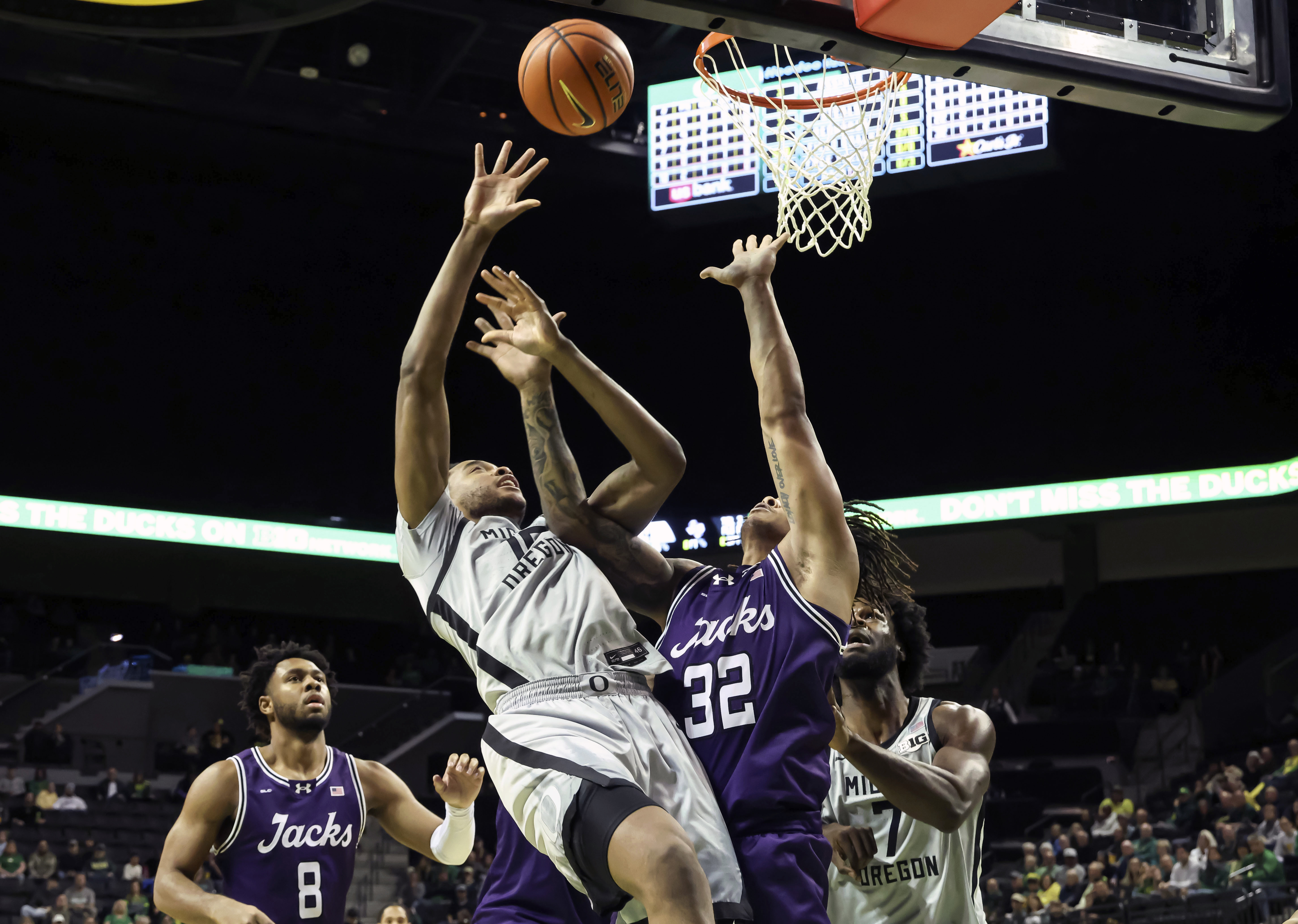 Oregon forward Kwame Evans Jr., center left, shoots against Stephen F. Austin forward Juhlawnei Stone (32) during the first half of an NCAA college basketball game in Eugene, Ore., Sunday, Dec. 15, 2024. 