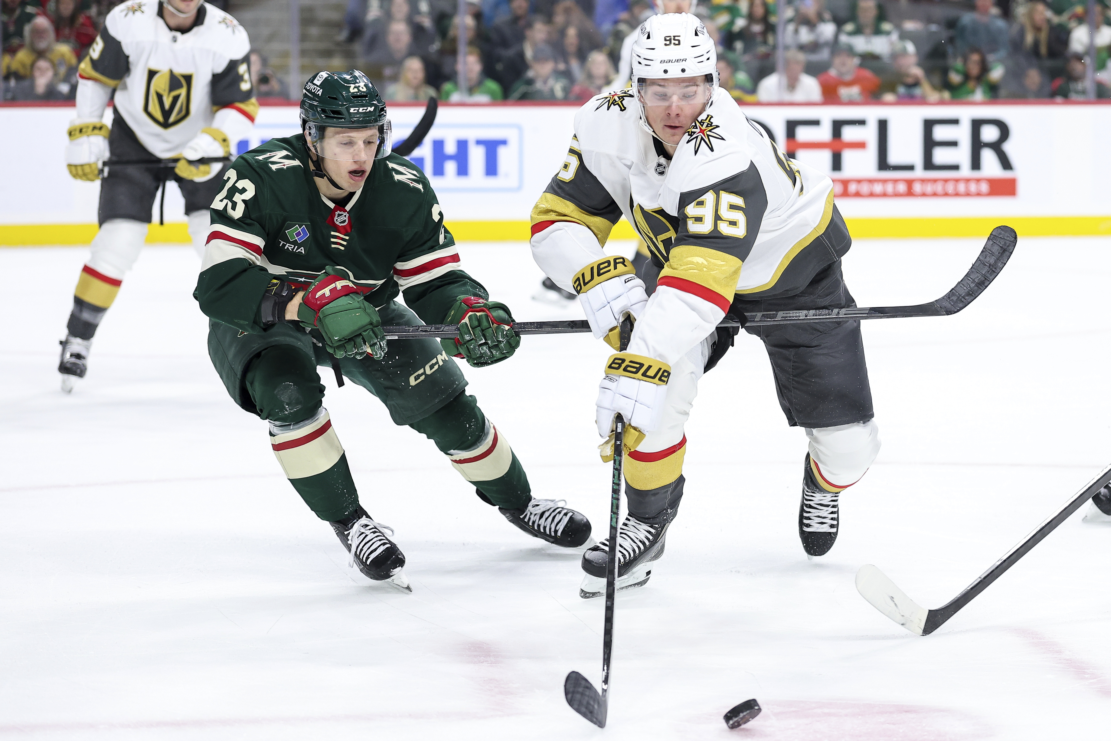 Vegas Golden Knights right wing Victor Olofsson, right, and Minnesota Wild center Marco Rossi (23) compete for the puck during the first period of an NHL hockey game Sunday, Dec. 15, 2024, in St. Paul, Minn. 