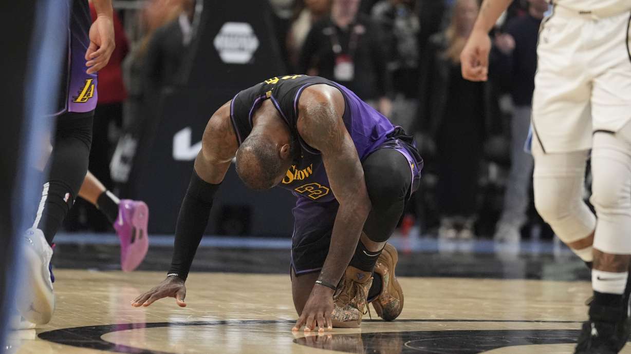 Los Angeles Lakers forward LeBron James (23) kneels on the court in the second half of an NBA basketball game against the Atlanta Hawks, Friday, Dec. 6, 2024, in Atlanta.