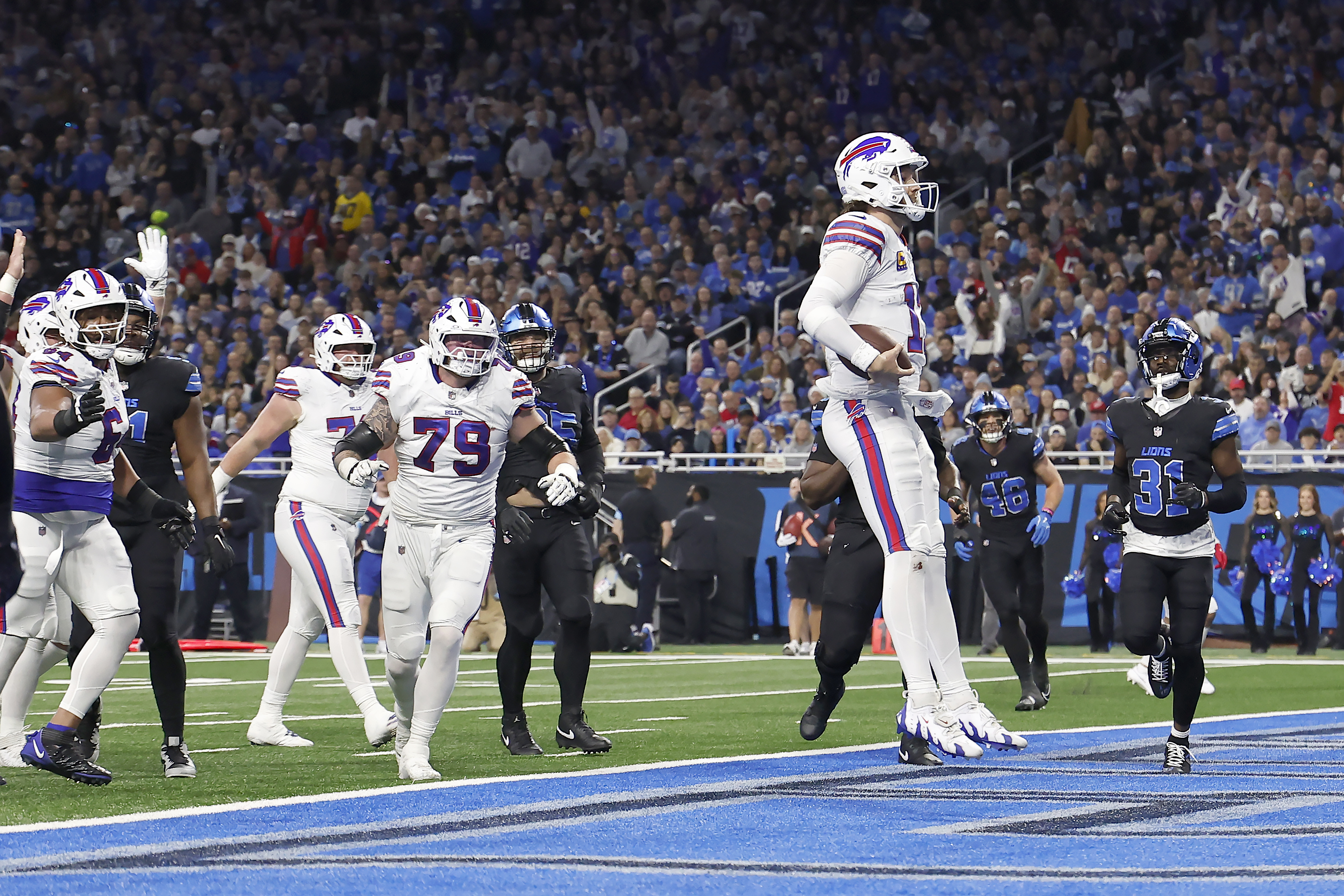 Buffalo Bills quarterback Josh Allen, foreground, celebrates after scoring against the Detroit Lions during the first half of an NFL football game, Sunday, Dec. 15, 2024, in Detroit. 
