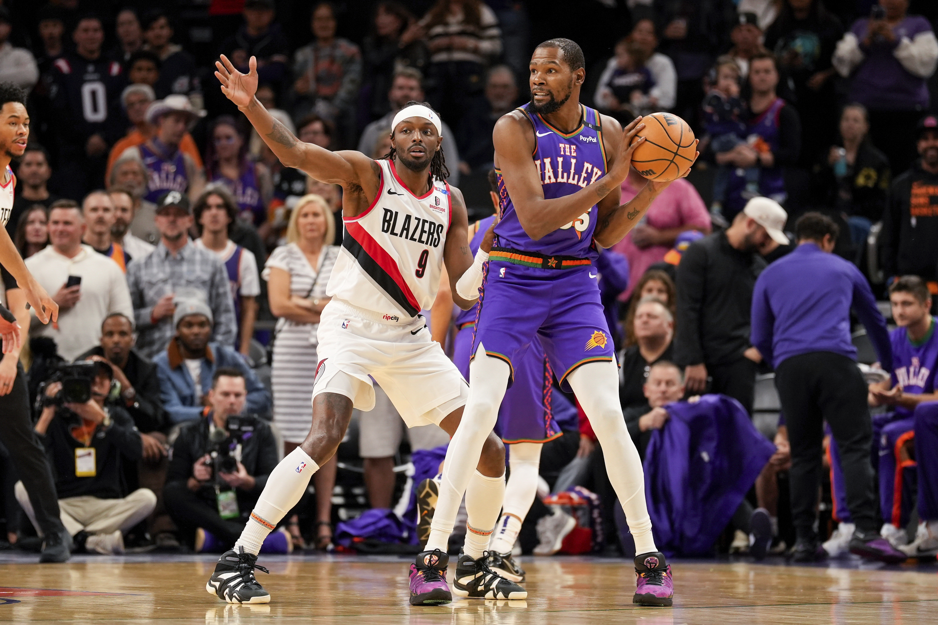 Portland Trail Blazers forward Jerami Grant (9) guards Phoenix Suns forward Kevin Durant (35) during the first half of an NBA basketball game, Sunday, Dec. 15, 2024, in Phoenix. 