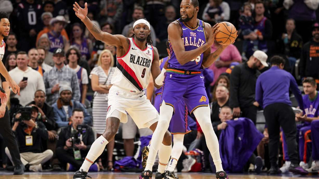 Portland Trail Blazers forward Jerami Grant (9) guards Phoenix Suns forward Kevin Durant (35) during the first half of an NBA basketball game, Sunday, Dec. 15, 2024, in Phoenix.