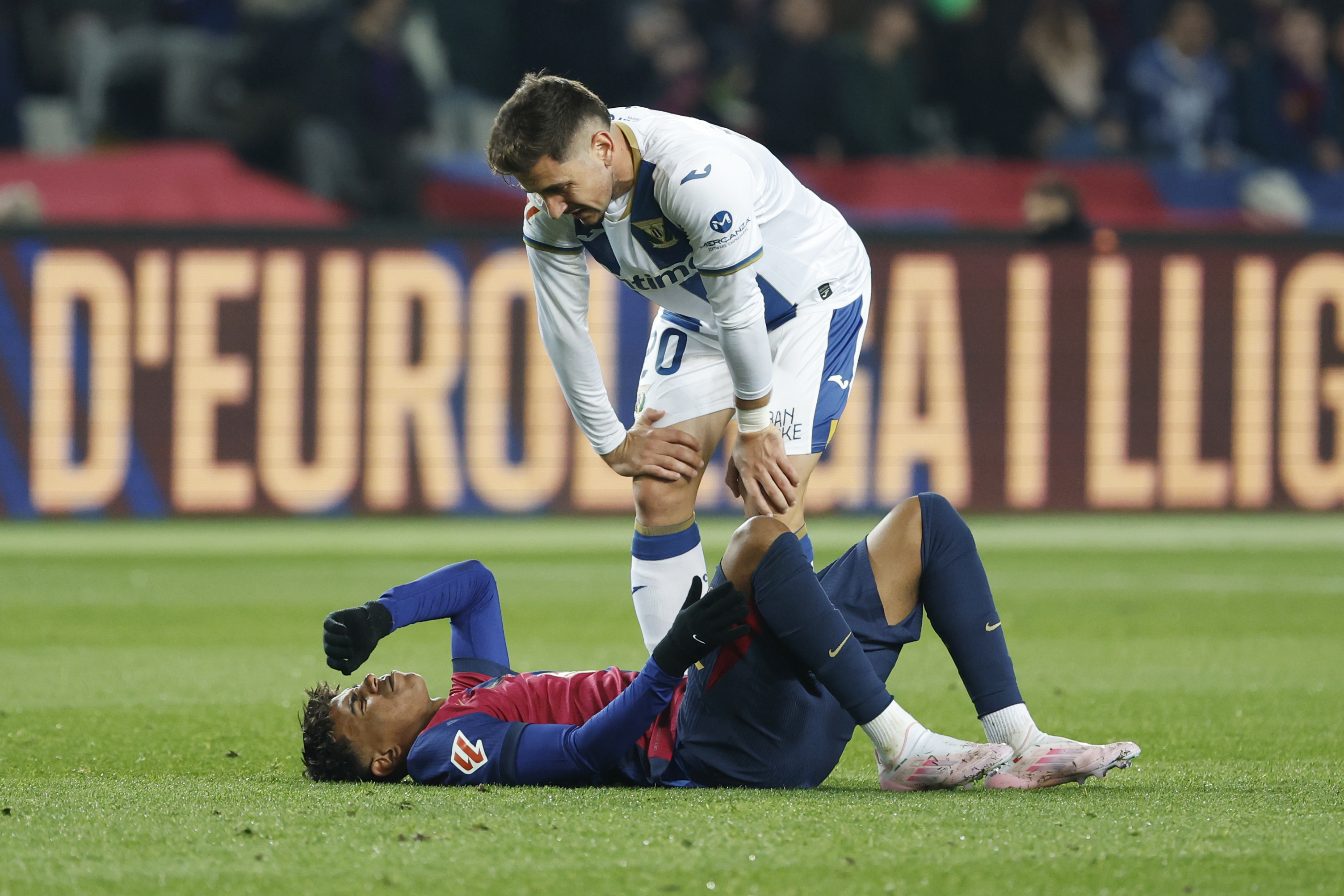 Leganes' Javi Hernandez, top, talks to Barcelona's Lamine Yamal as he lies on the pitch after a challenge during the Spanish La Liga soccer match between Barcelona and Leganes at the Lluis Companys Olympic Stadium in Barcelona, Spain, Sunday, Dec. 15, 2024. 
