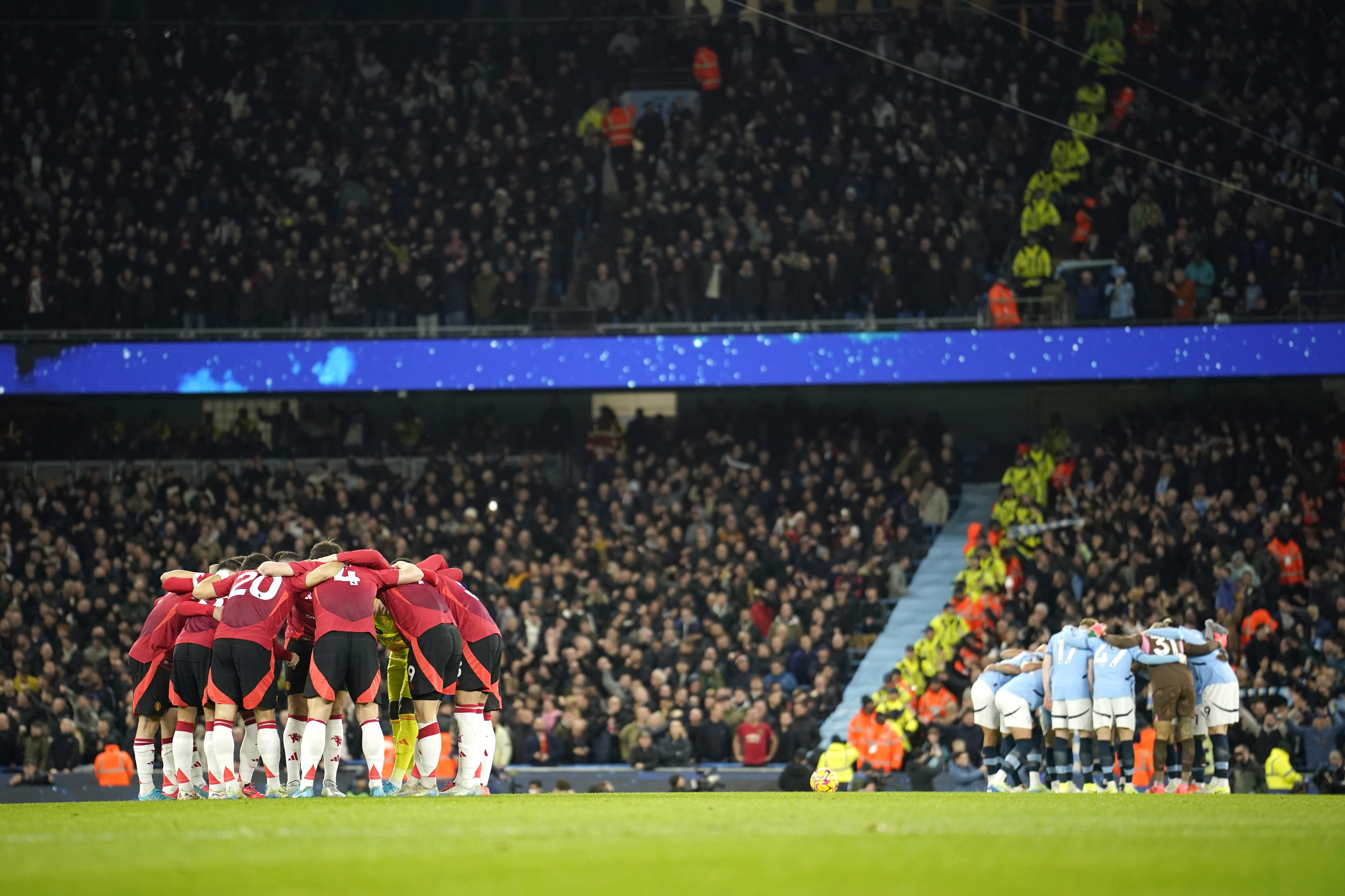 Manchester City and Manchester United, left, teams huddle just prior to kick off of the English Premier League soccer match between Manchester City and Manchester United at the Etihad Stadium in Manchester, Sunday, Dec. 15, 2024. 