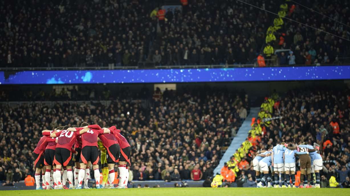 Manchester City and Manchester United, left, teams huddle just prior to kick off of the English Premier League soccer match between Manchester City and Manchester United at the Etihad Stadium in Manchester, Sunday, Dec. 15, 2024.