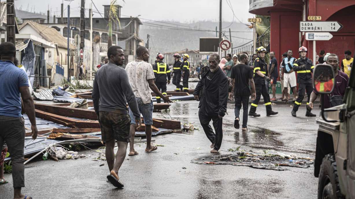 This photo provided on Monday by the Civil Security shows residents and rescue workers walking in a damaged street in French territory of Mayotte in the Indian Ocean, after the island was battered by its worst cyclone in nearly a century.