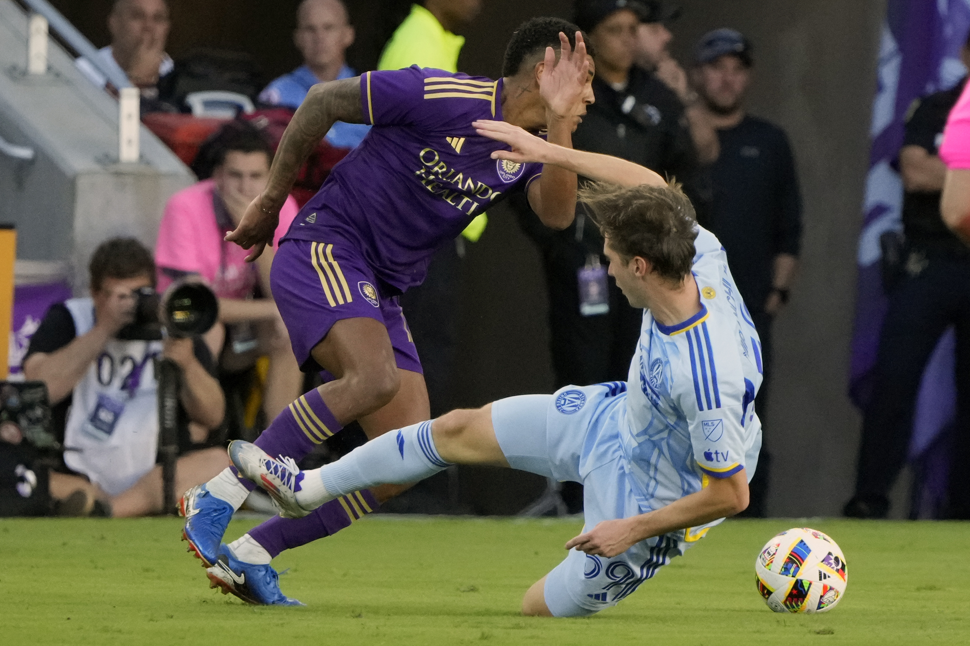 Orlando City's Wilder Cartagena, left, goes past Atlanta United's Aleksey Miranchuk during the second half of an MLS Semifinal Conference playoff soccer match, Sunday, Nov. 24, 2024, in Orlando, Fla. 