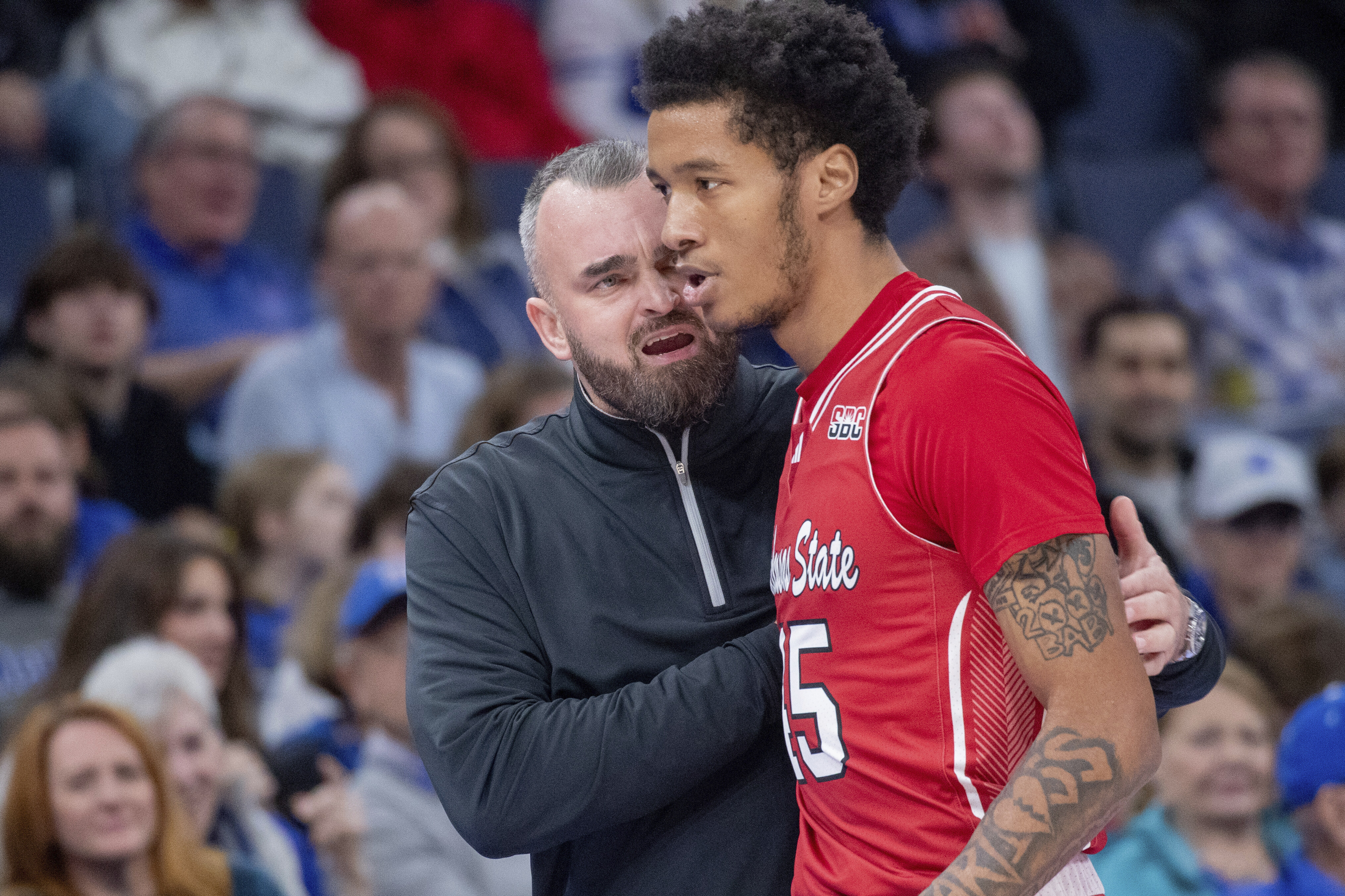 Arkansas State head coach Bryan Hodgson talks with Arkansas State forward Dyondre Dominguez during the first half of an NCAA college basketball game, Sunday, Dec. 8, 2024, in Memphis, Tenn. 