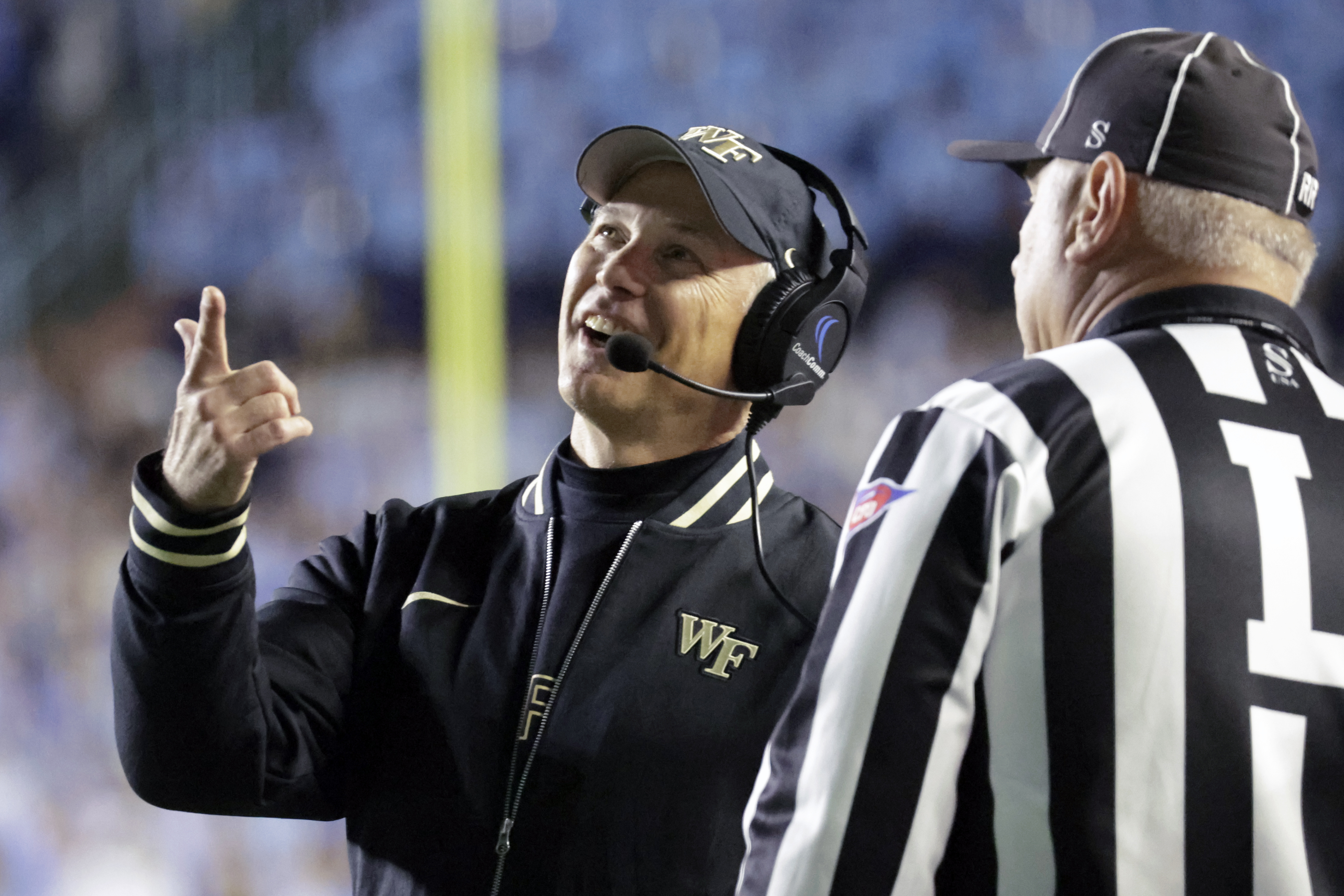 Wake Forest head coach Dave Clawson looks at a replay on the scoreboard as he discusses a call with an official during the first half of an NCAA college football game against North Carolina, Saturday, Nov. 16, 2024, in Chapel Hill, N.C. 