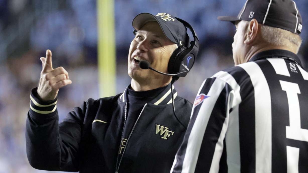 Wake Forest head coach Dave Clawson looks at a replay on the scoreboard as he discusses a call with an official during the first half of an NCAA college football game against North Carolina, Saturday, Nov. 16, 2024, in Chapel Hill, N.C.