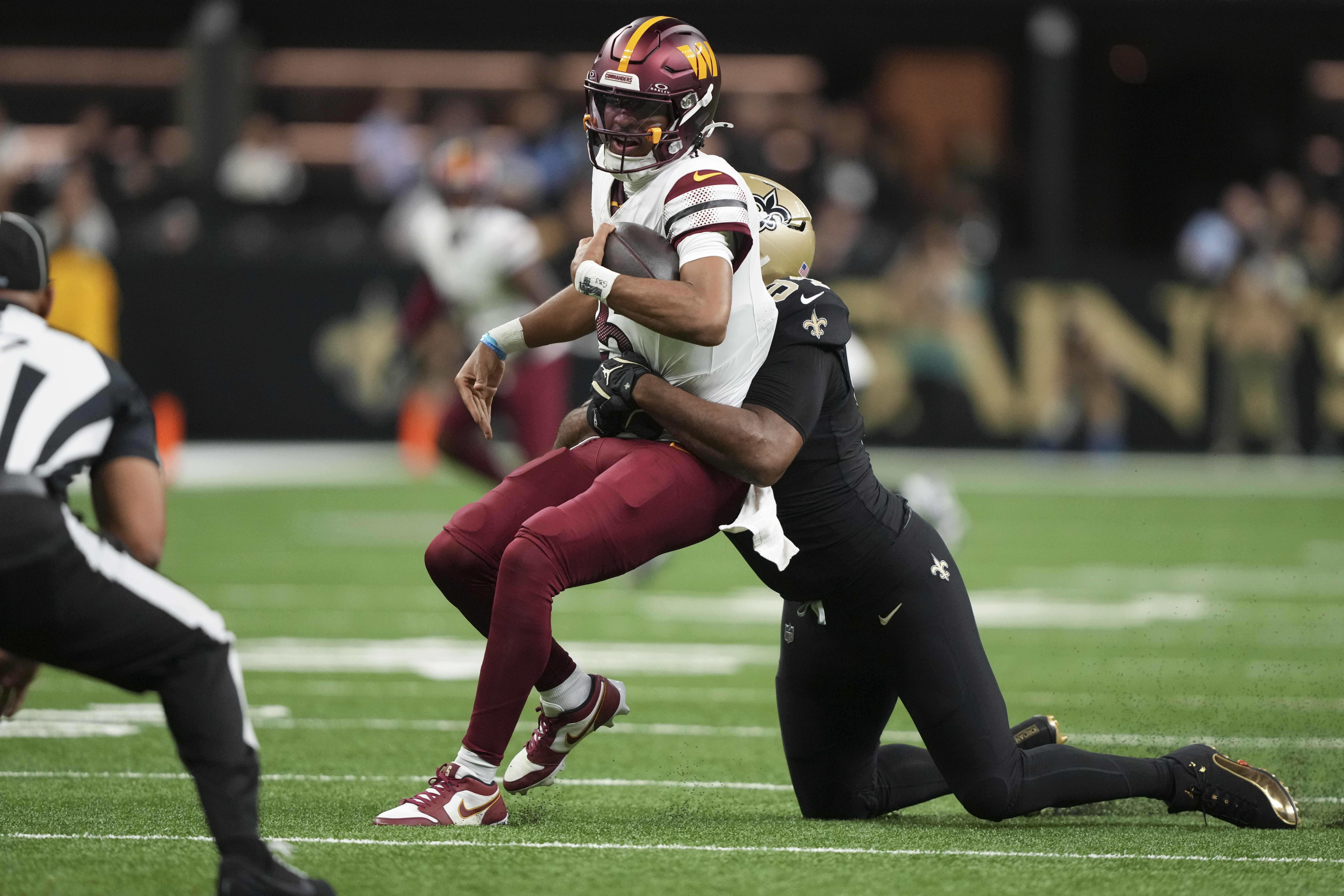 New Orleans Saints defensive end Cameron Jordan (94) sacks Washington Commanders quarterback Jayden Daniels (5) in the first half of an NFL football game in New Orleans, Sunday, Dec. 15, 2024. 