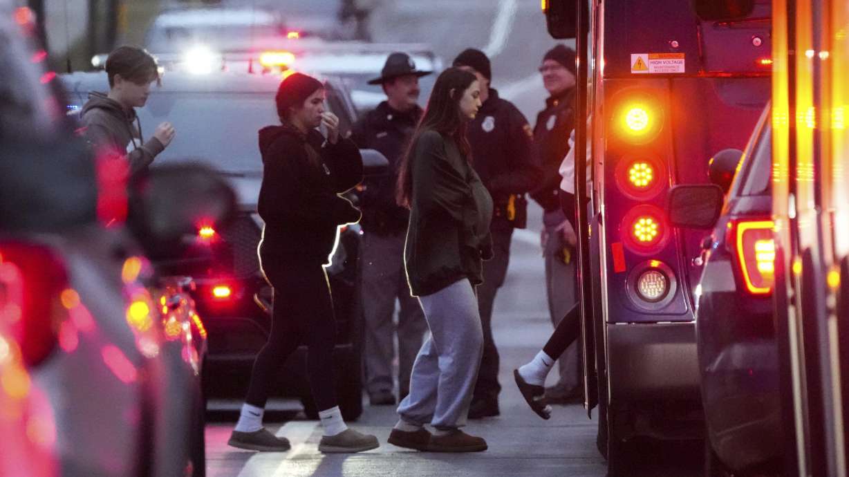 Students board a bus as they leave the shelter following a shooting at the Abundant Life Christian School, Monday, in Wisconsin. A teacher and a student died in the Monday shooting.