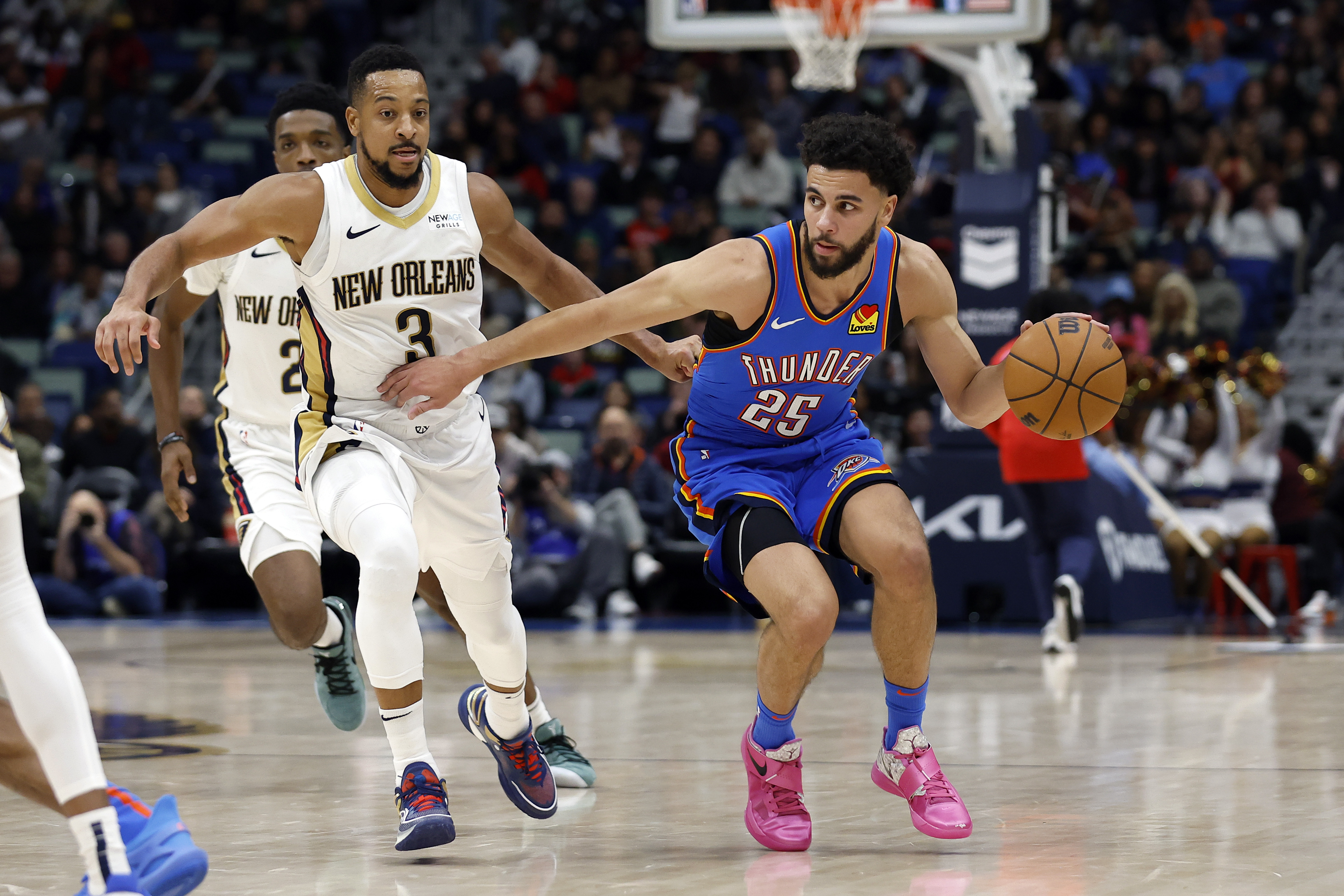 Oklahoma City Thunder guard Ajay Mitchell (25) drives to the basket past New Orleans Pelicans guard CJ McCollum (3) in the second half of an NBA basketball game in New Orleans, Saturday, Dec. 7, 2024. The Thunder won 119-109. 