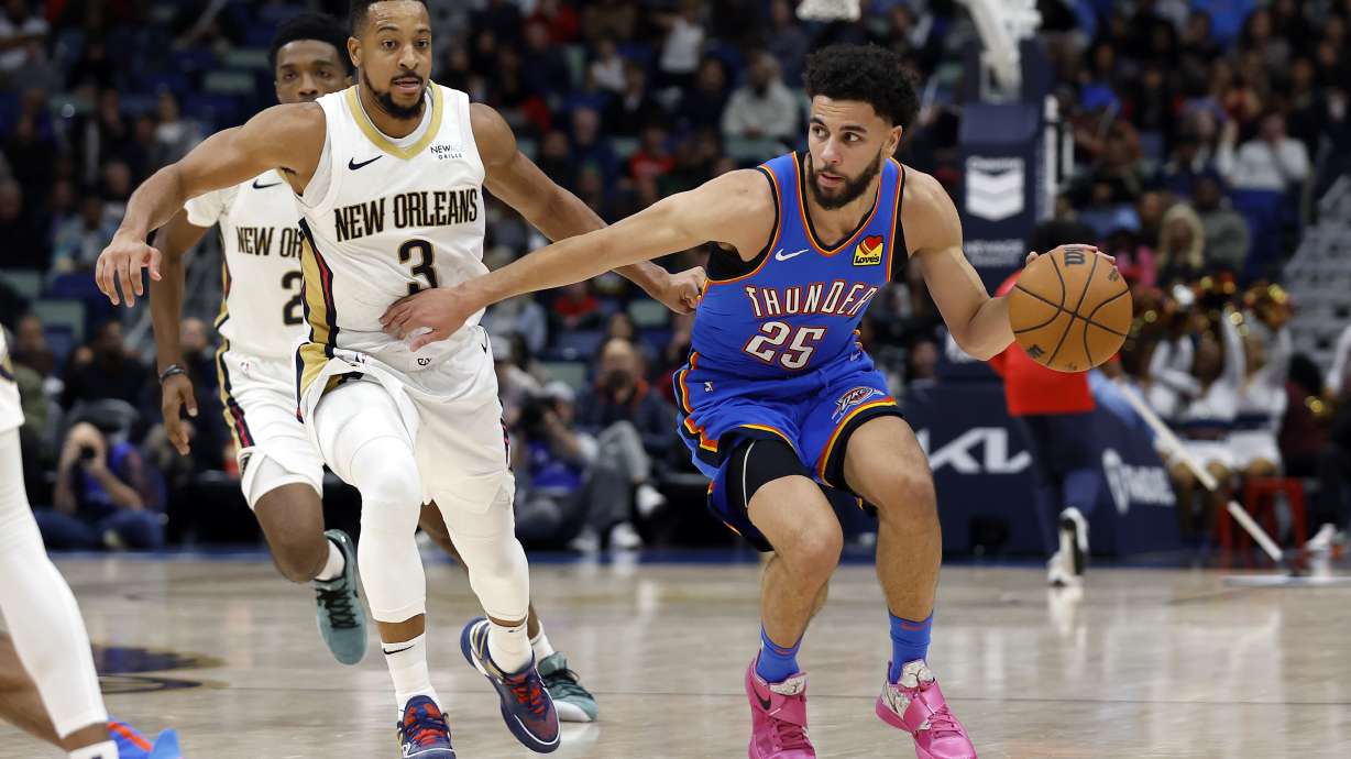 Oklahoma City Thunder guard Ajay Mitchell (25) drives to the basket past New Orleans Pelicans guard CJ McCollum (3) in the second half of an NBA basketball game in New Orleans, Saturday, Dec. 7, 2024. The Thunder won 119-109.