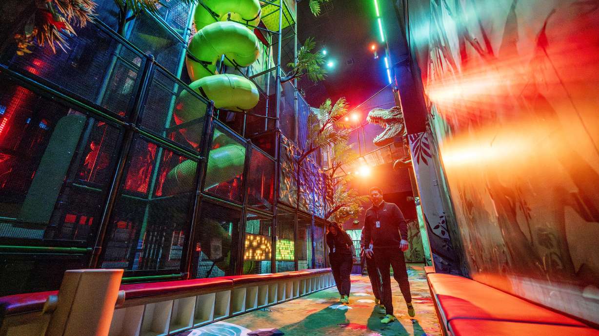 Employees walk in the new Jurassic Jungle play area in what was previously the IMAX theater space at Thanksgiving Point on Monday.
