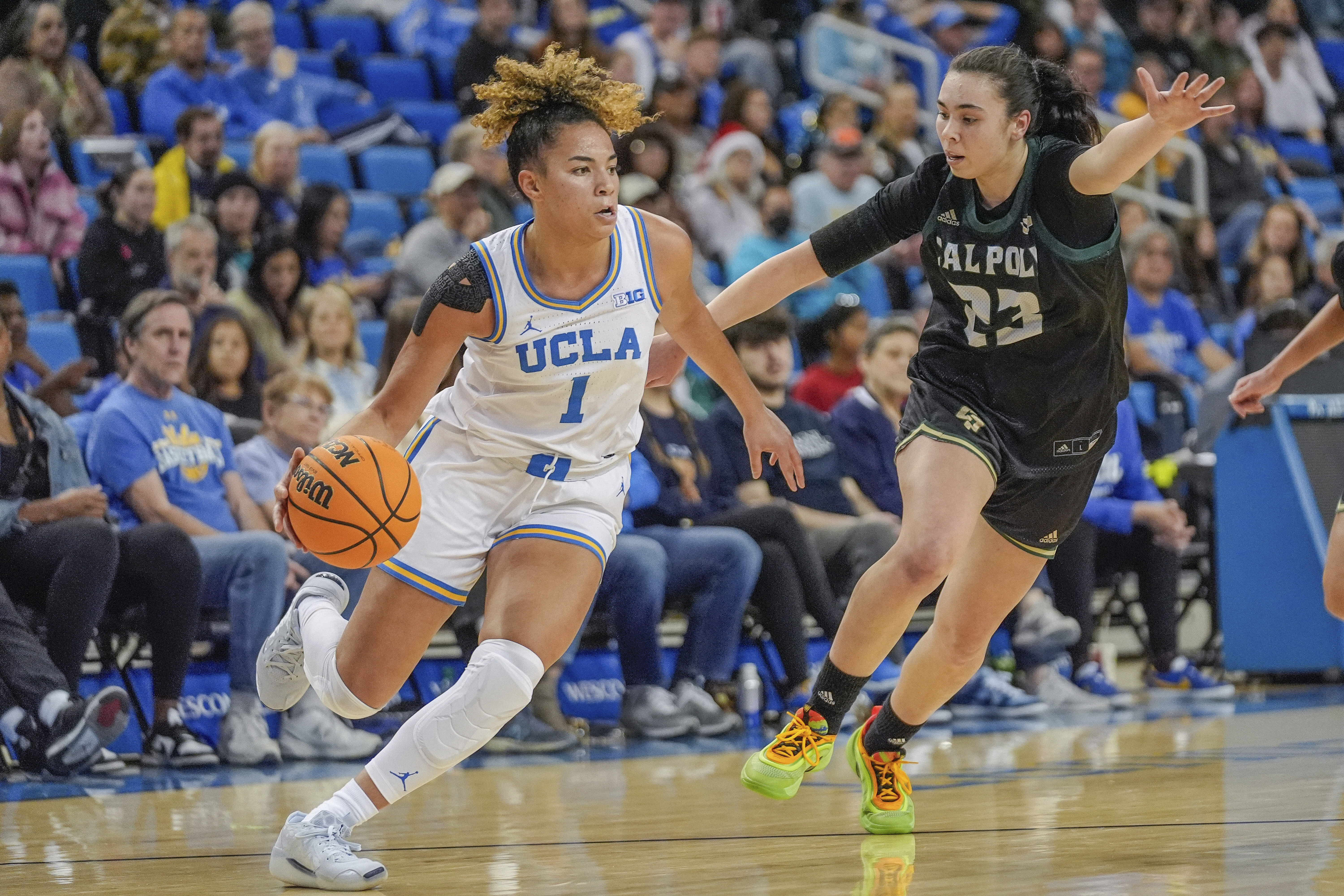UCLA guard Kiki Rice (1) controls the ball against Cal Poly guard Ana Moleon Hidalgo (23) during the first half of an NCAA college basketball game in Los Angeles, Monday, Dec. 16, 2024. 