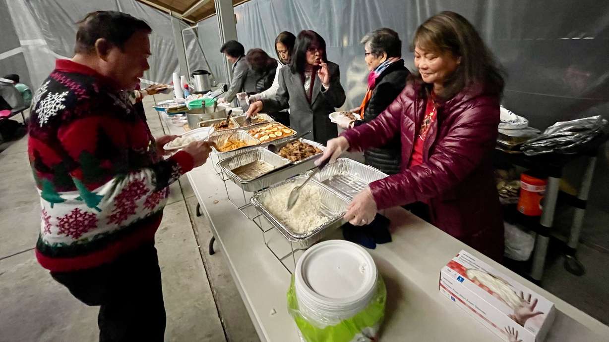 Marius Bondoc, left, at a shared meal after a Simbang Gabi service on Monday at Our Lady of Guadalupe Catholic Church in Salt Lake City. Simbang Gabi is a Christmastime tradition among Catholic Filipinos.