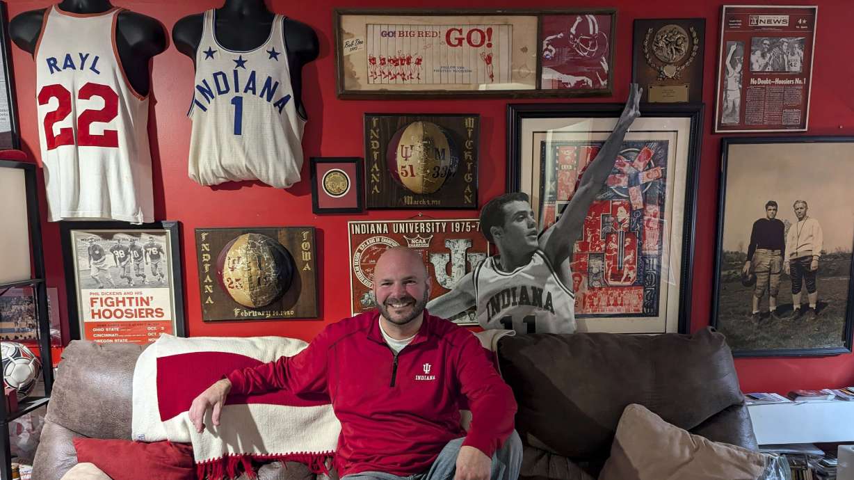 In this photo provided by Heather White, Indiana Hoosiers fan Brett White pose Monday, Dec. 16, 2024, at his home in Bloomington, Ind. White and other Indiana fans are riding the euphoria of a great season that culminated in a berth in the College Football Playoff. The Hoosiers will meet Notre Dame on Friday night in South Bend, Ind.
