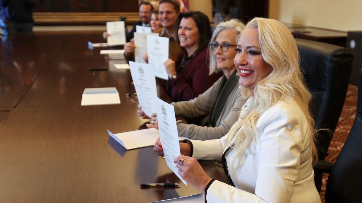 Kristen Small and other electors show certificates of election for the president and vice president after filing out electoral votes at the Capitol in Salt Lake City on Tuesday.