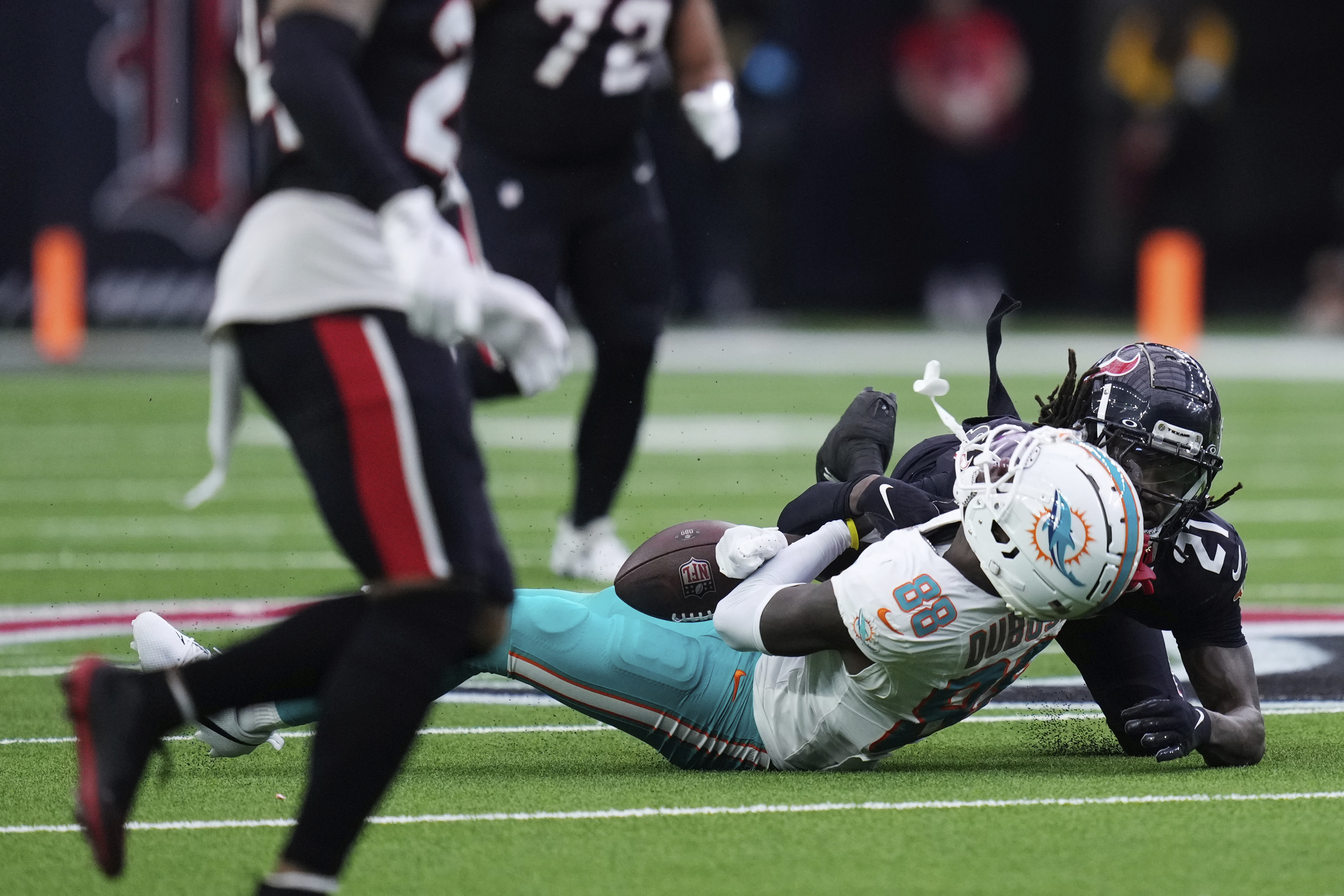 Miami Dolphins wide receiver Grant DuBose (88) is brought down by Houston Texans safety Calen Bullock (21) on a play that left DuBose injured, during the second half of an NFL football game Sunday, Dec. 15, 2024, in Houston. 