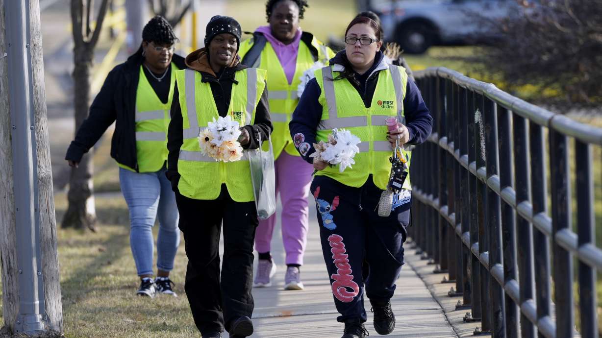 A group makes their way to leave flowers outside the Abundant Life Christian School Tuesday, Dec. 17, 2024 in Madison, Wis., following a shooting on Monday.