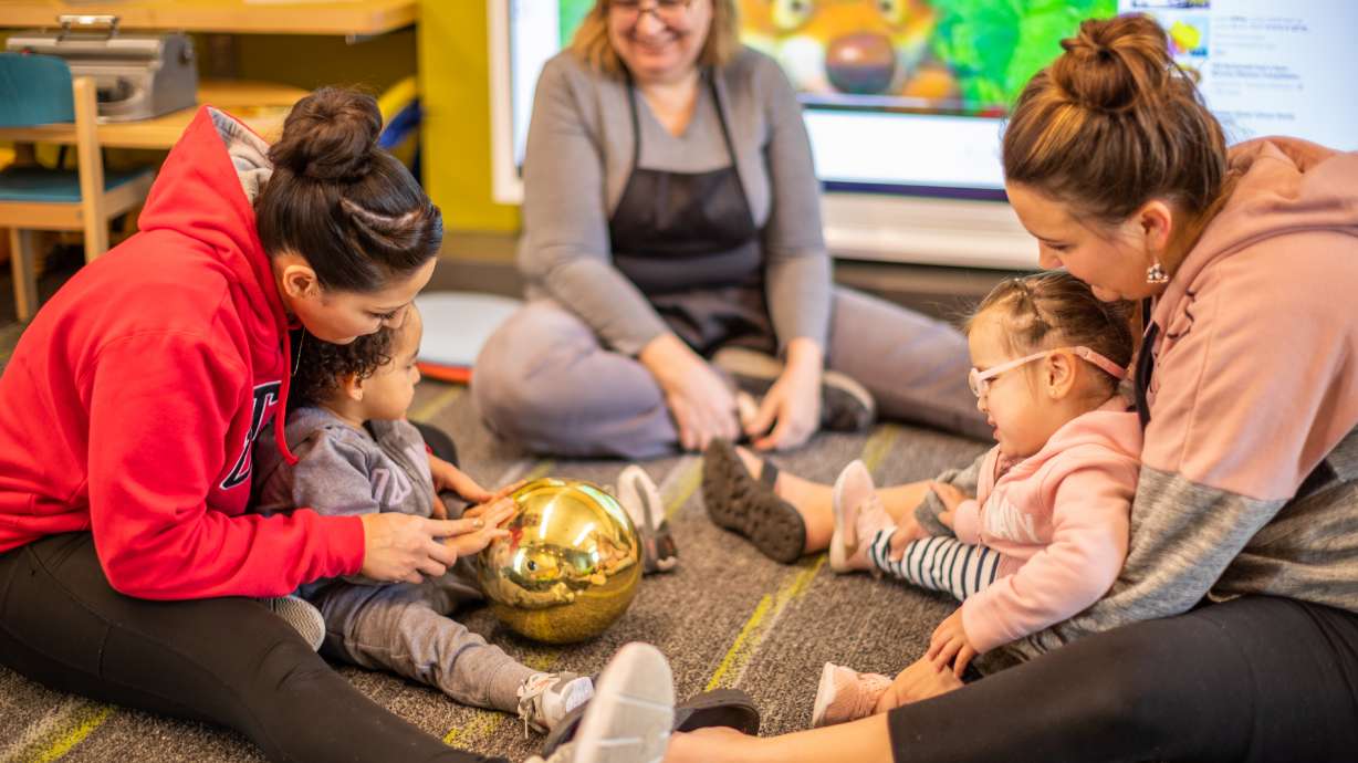 A Parent Infant Program provider, center, helps parents lead activities with their children who are blind. The program is for children ages zero to 3 years old who are blind, vision-impaired, deaf or have a loss of hearing..