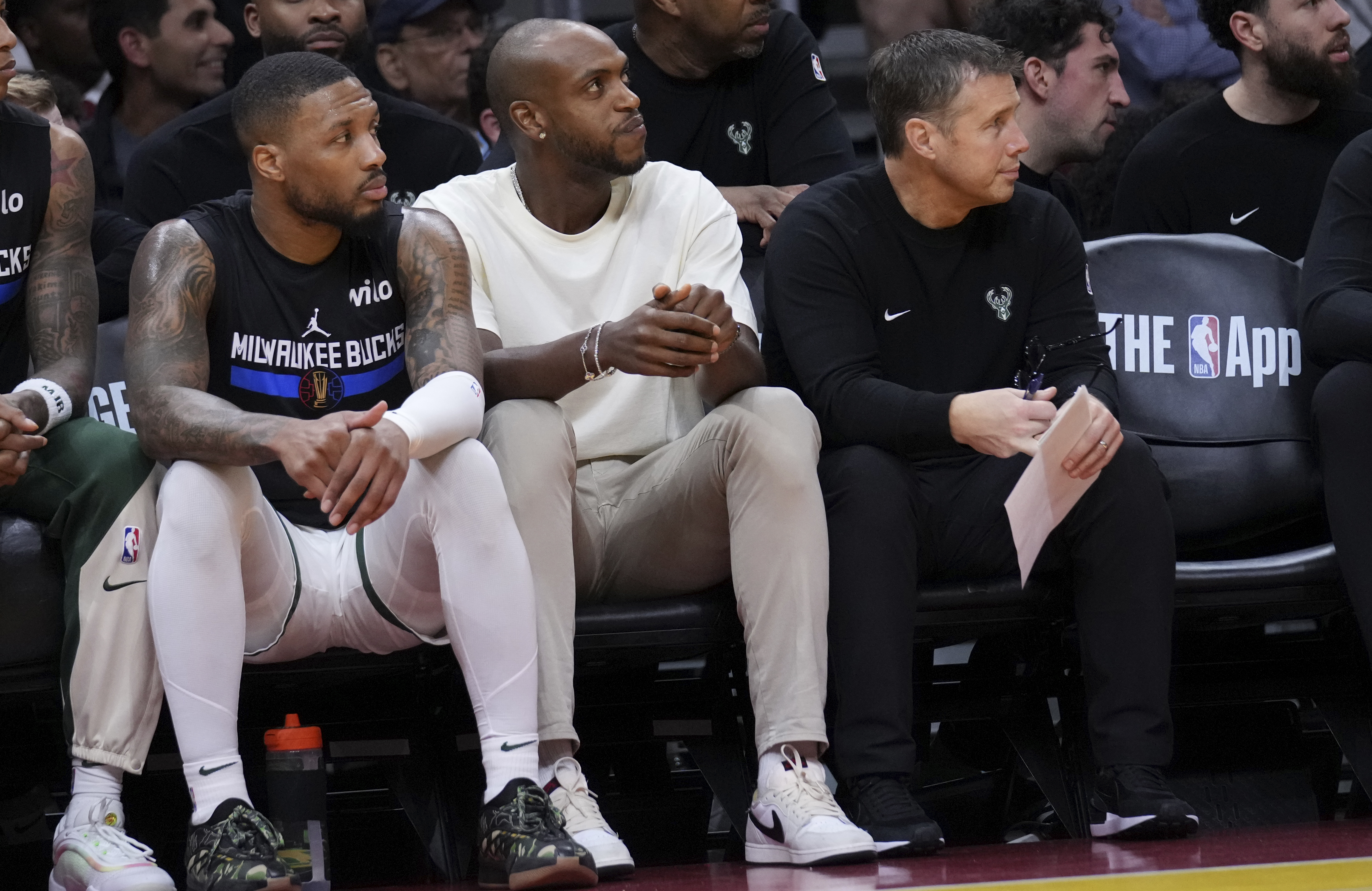 Milwaukee Bucks forward Khris Middleton, center, sits next to guard Damian Lillard, left, during the first half of an Emirates NBA Cup basketball game against the Miami Heat, Tuesday, Nov. 26, 2024, in Miami.