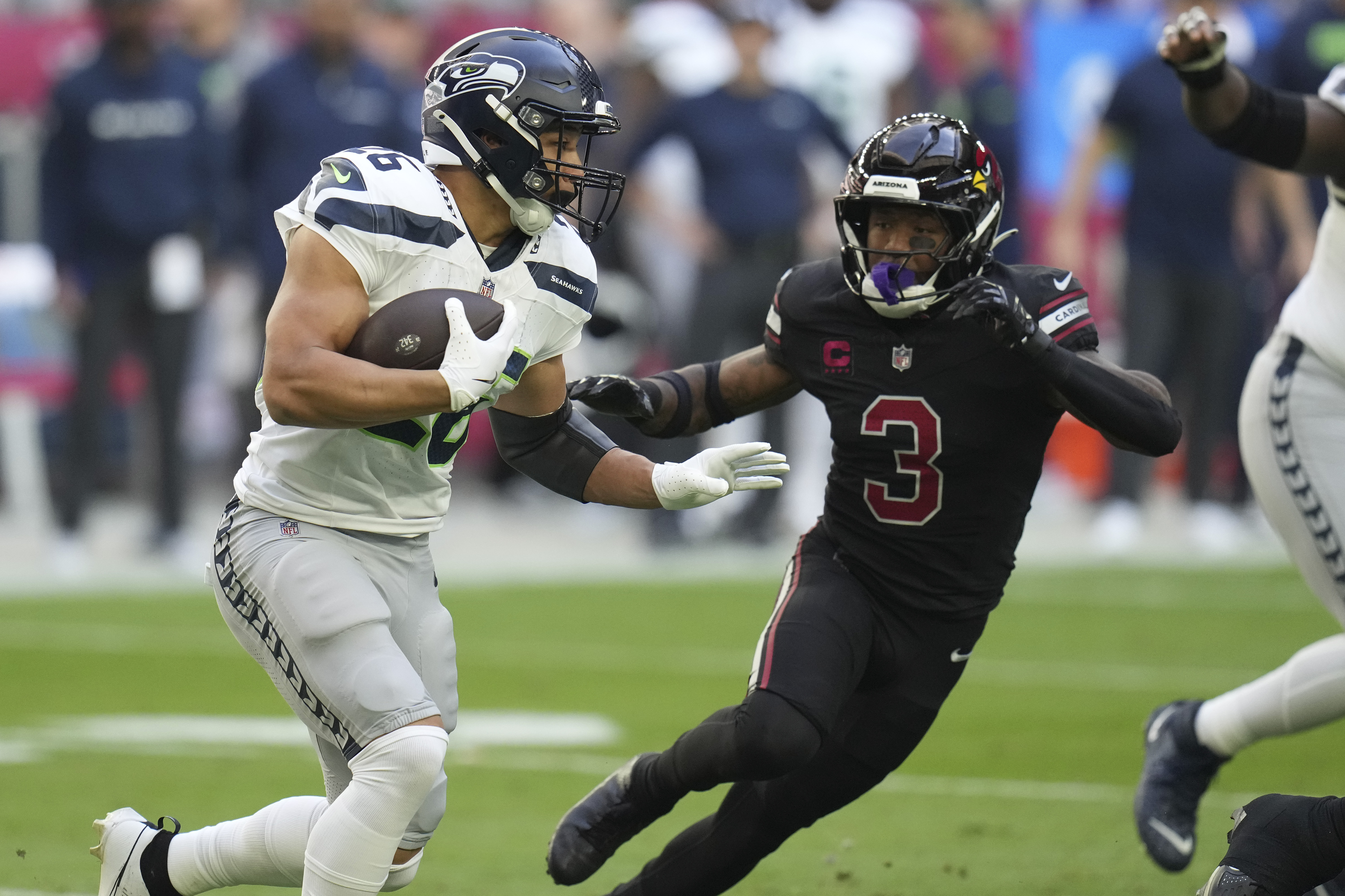 Seattle Seahawks running back Zach Charbonnet runs as Arizona Cardinals safety Budda Baker (3) defends during the first half of an NFL football game, Sunday, Dec. 8, 2024, in Glendale, Ariz. 