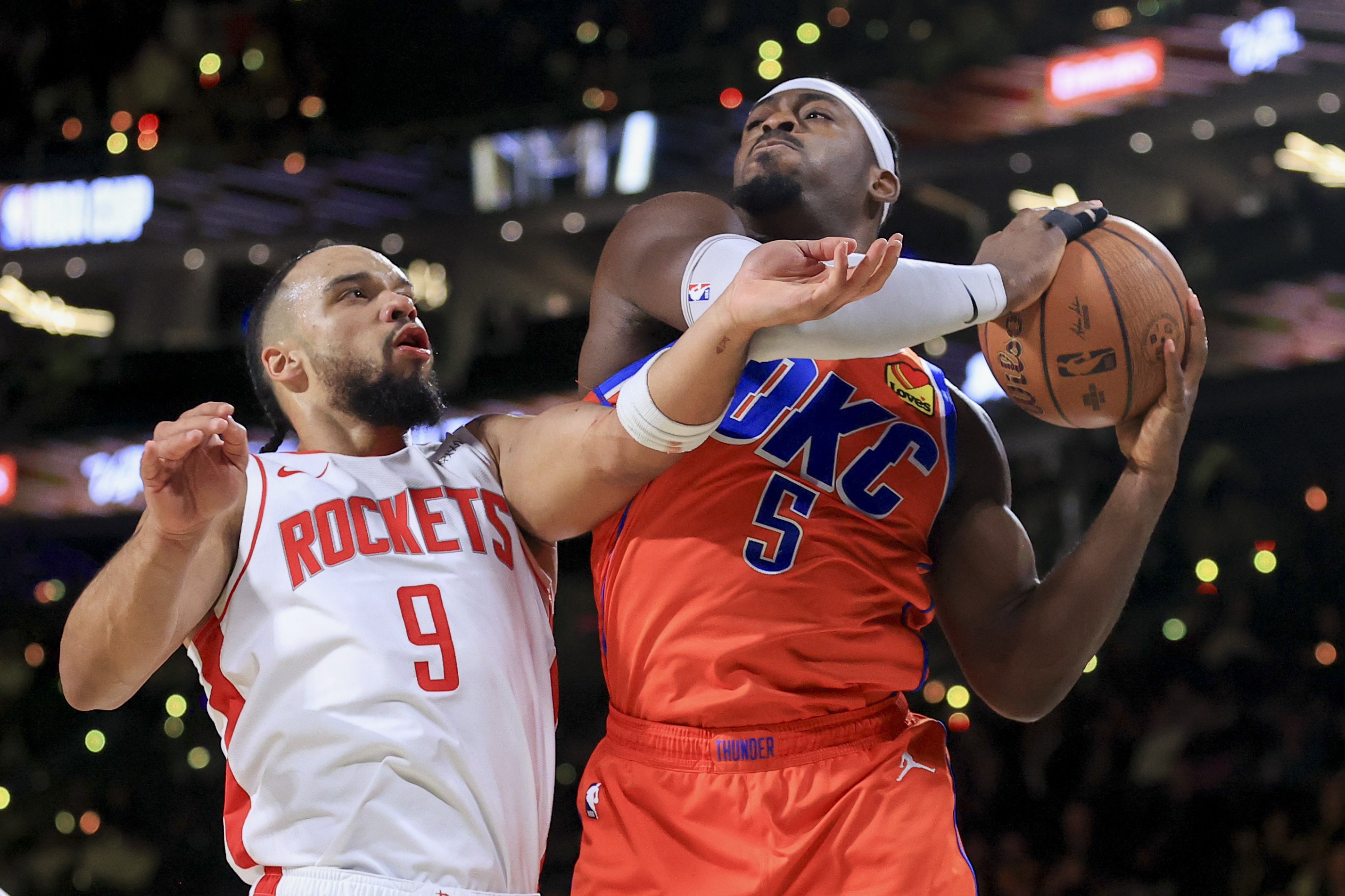Houston Rockets forward Dillon Brooks (9) and Oklahoma City Thunder guard Luguentz Dort (5) contest for a rebound during the second half of a semifinal game in the NBA Cup basketball tournament Saturday, Dec. 14, 2024, in Las Vegas. 