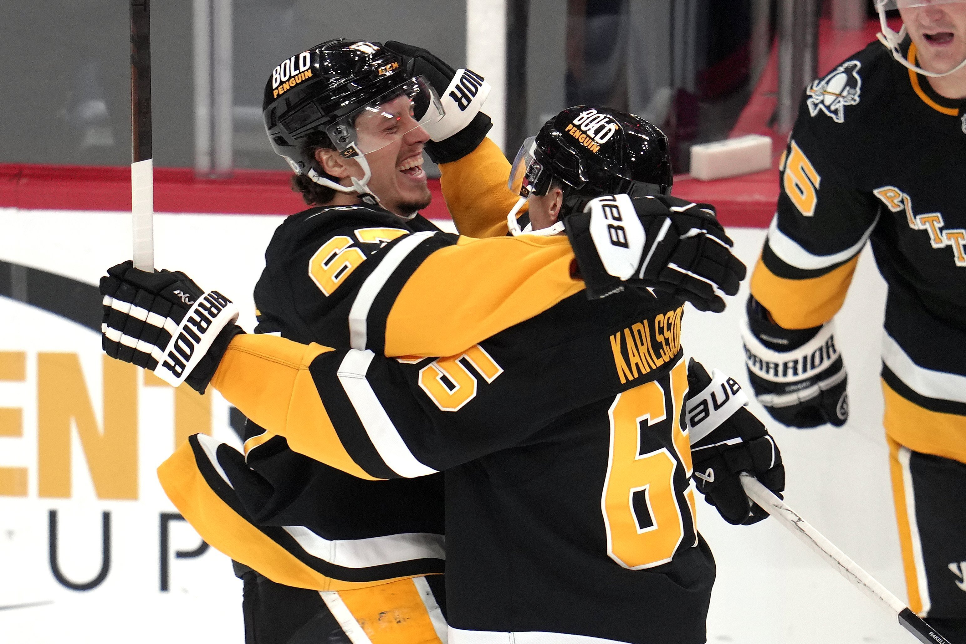 Pittsburgh Penguins' Rickard Rakell, left, celebrates his game-winning goal with Erik Karlsson (65), in the overtime period of an NHL hockey game against the Los Angeles Kings in Pittsburgh, Tuesday, Dec. 17, 2024. The Penguins won 3-2. 