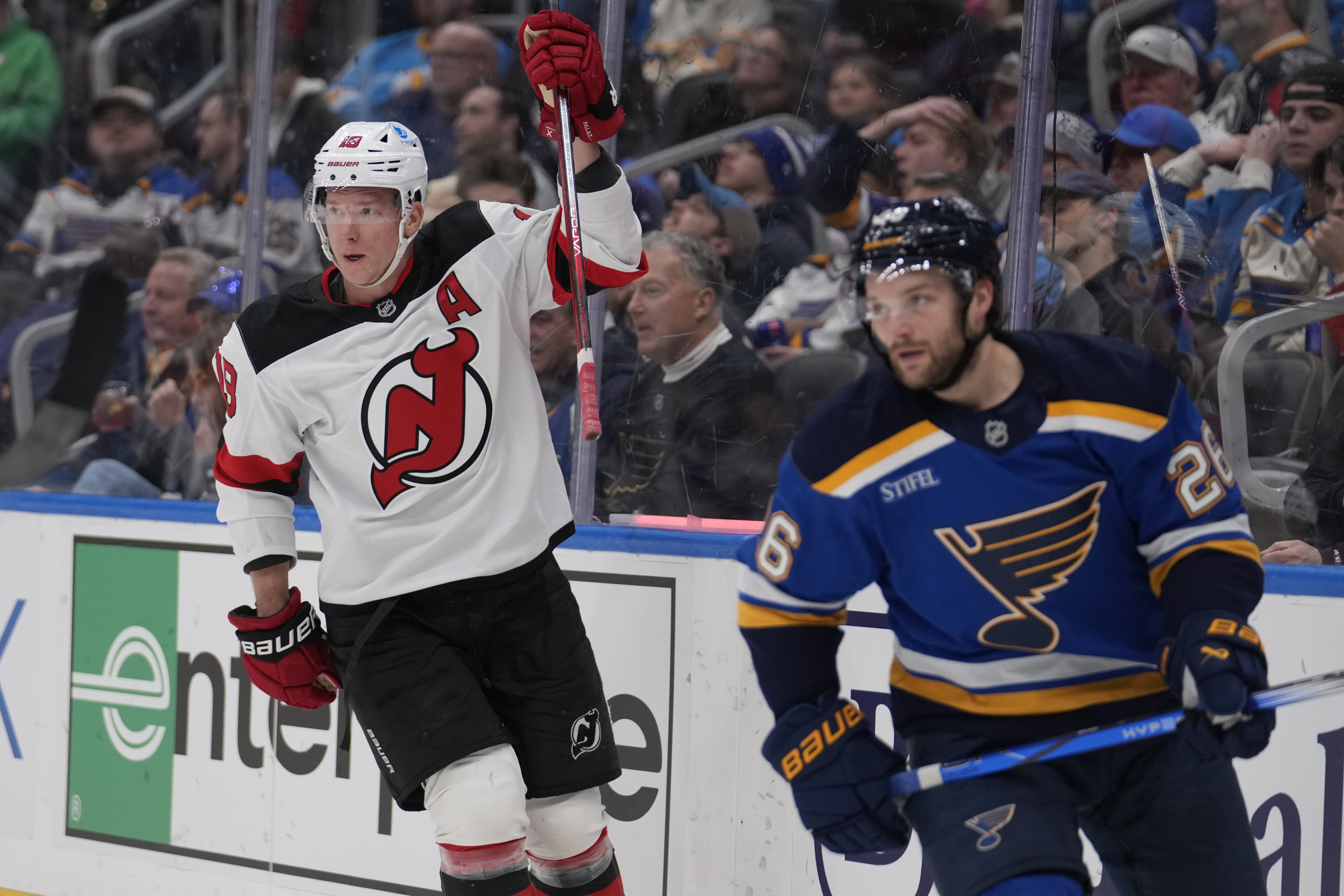 New Jersey Devils' Ondrej Palat (18) celebrates after scoring as St. Louis Blues' Nathan Walker (26) skates past during the first period of an NHL hockey game Tuesday, Dec. 17, 2024, in St. Louis.