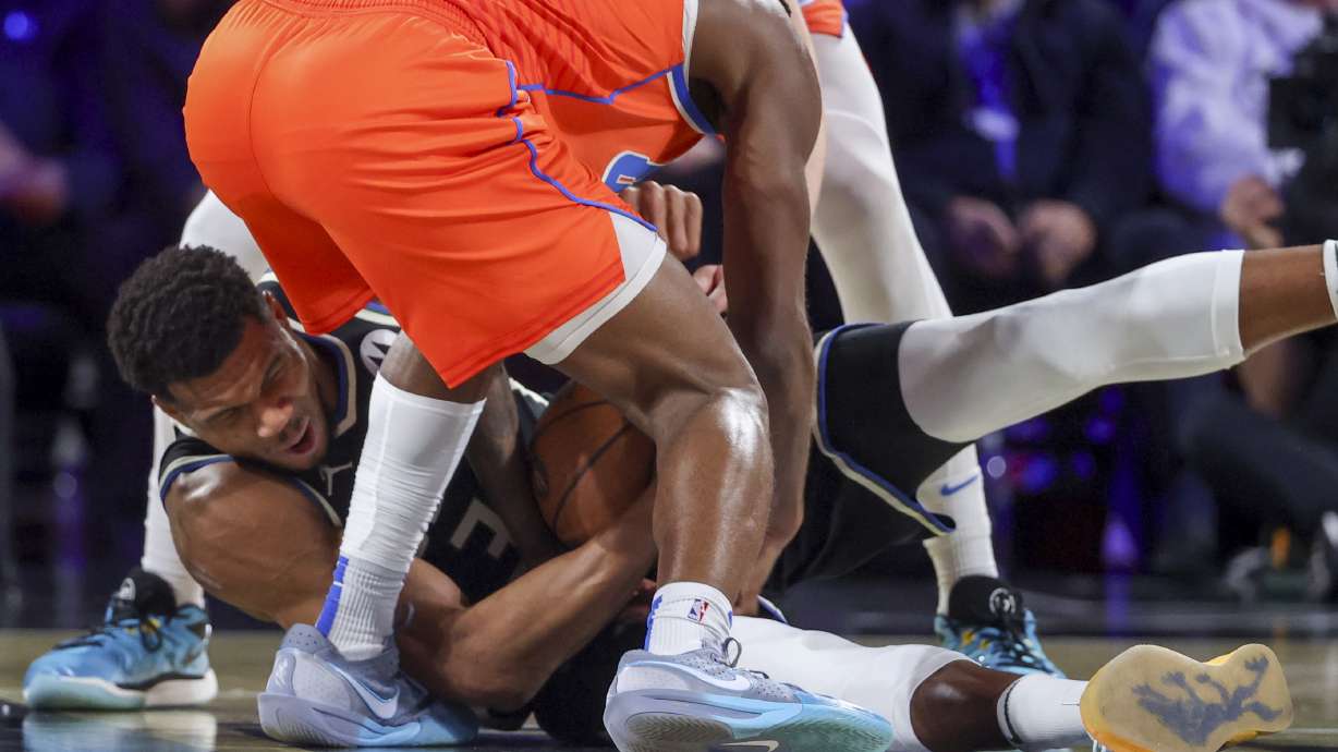 Milwaukee Bucks forward Giannis Antetokounmpo (34) wrestles for a loose ball with Oklahoma City Thunder guard Cason Wallace (22) during the first half of the championship game in the NBA Cup basketball tournament Tuesday, Dec. 17, 2024, in Las Vegas.