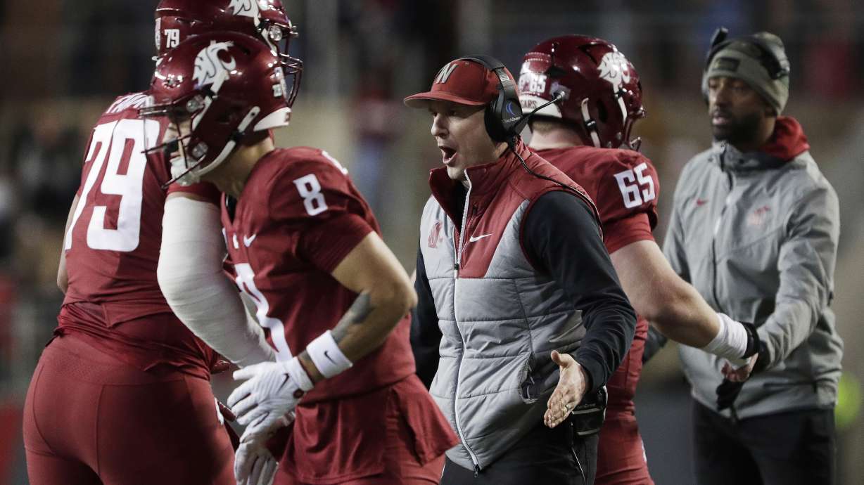 Washington State head coach Jake Dickert, center, celebrates after a touchdown with players leaving the field, including offensive lineman Fa'alili Fa'amoe (79), during the first half of an NCAA college football game against Wyoming, Saturday, Nov. 30, 2024, in Pullman, Wash.
