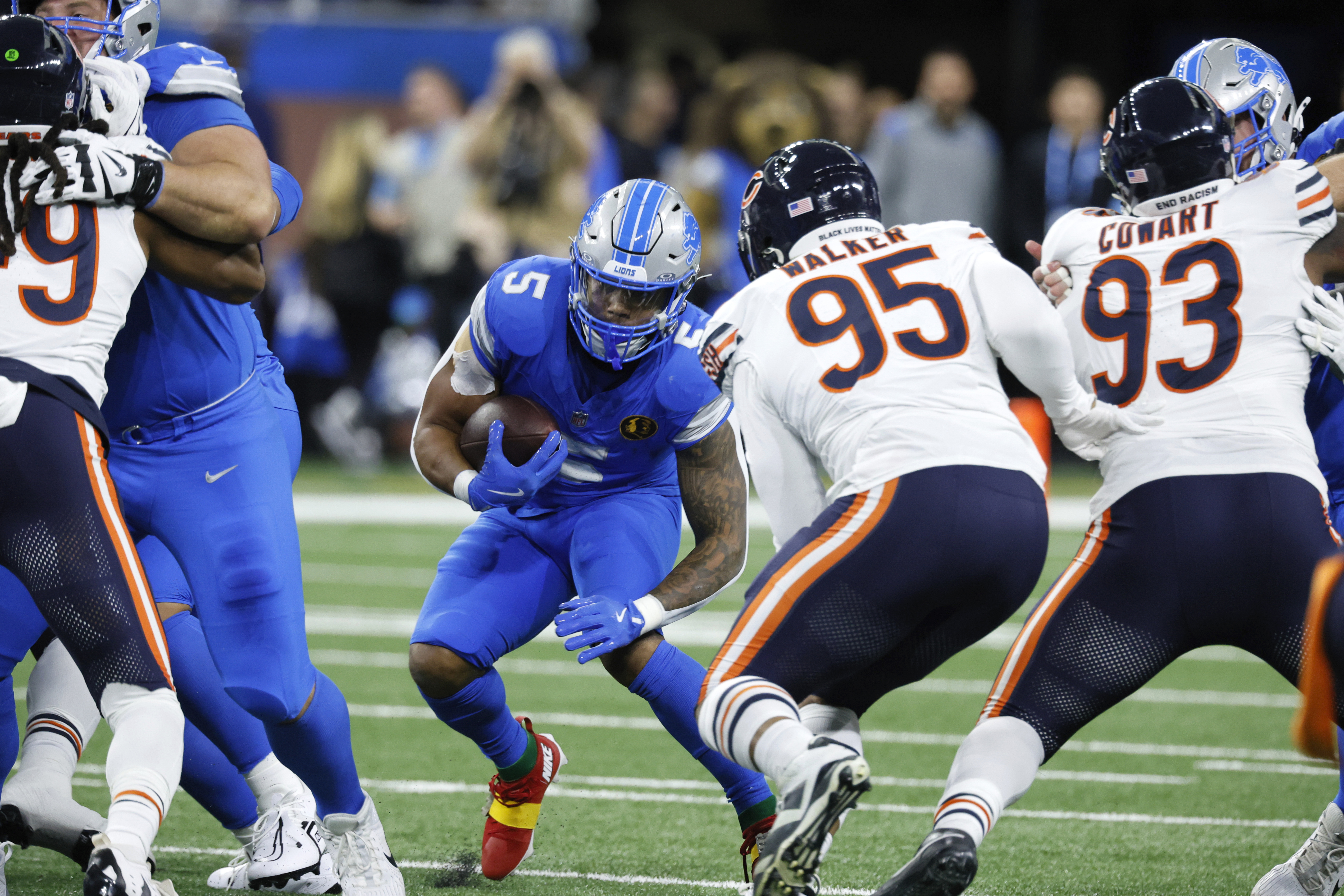 Detroit Lions running back David Montgomery (5) looks for running room as Chicago Bears defensive end DeMarcus Walker (95) defends during the first half of an NFL football game, Thursday, Nov. 28, 2024, in Detroit.