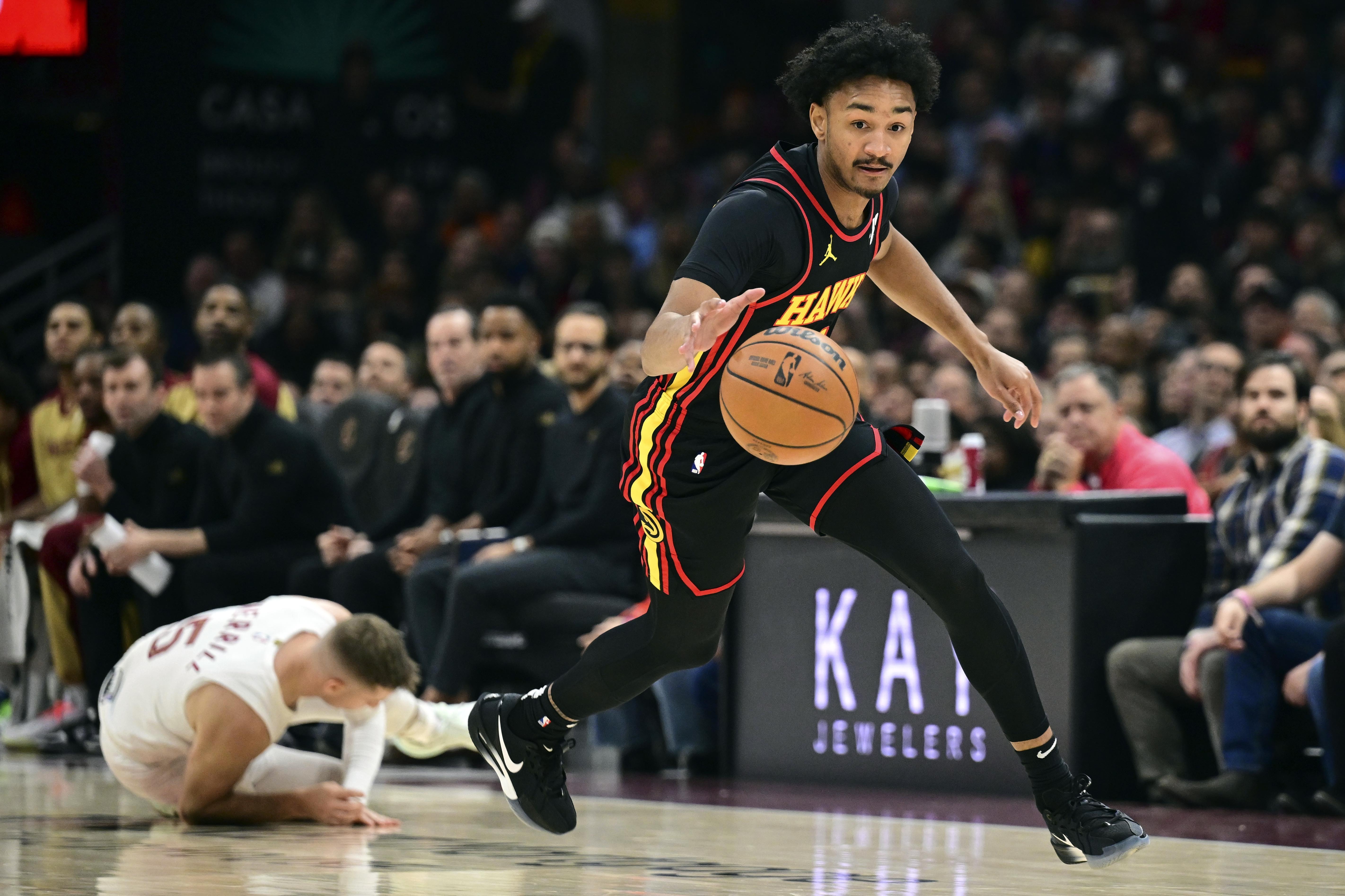 Atlanta Hawks guard Kobe Bufkin dribbles away from Cleveland Cavaliers guard Sam Merrill in the first half of an NBA basketball game, Wednesday, Nov. 27, 2024, in Cleveland. 