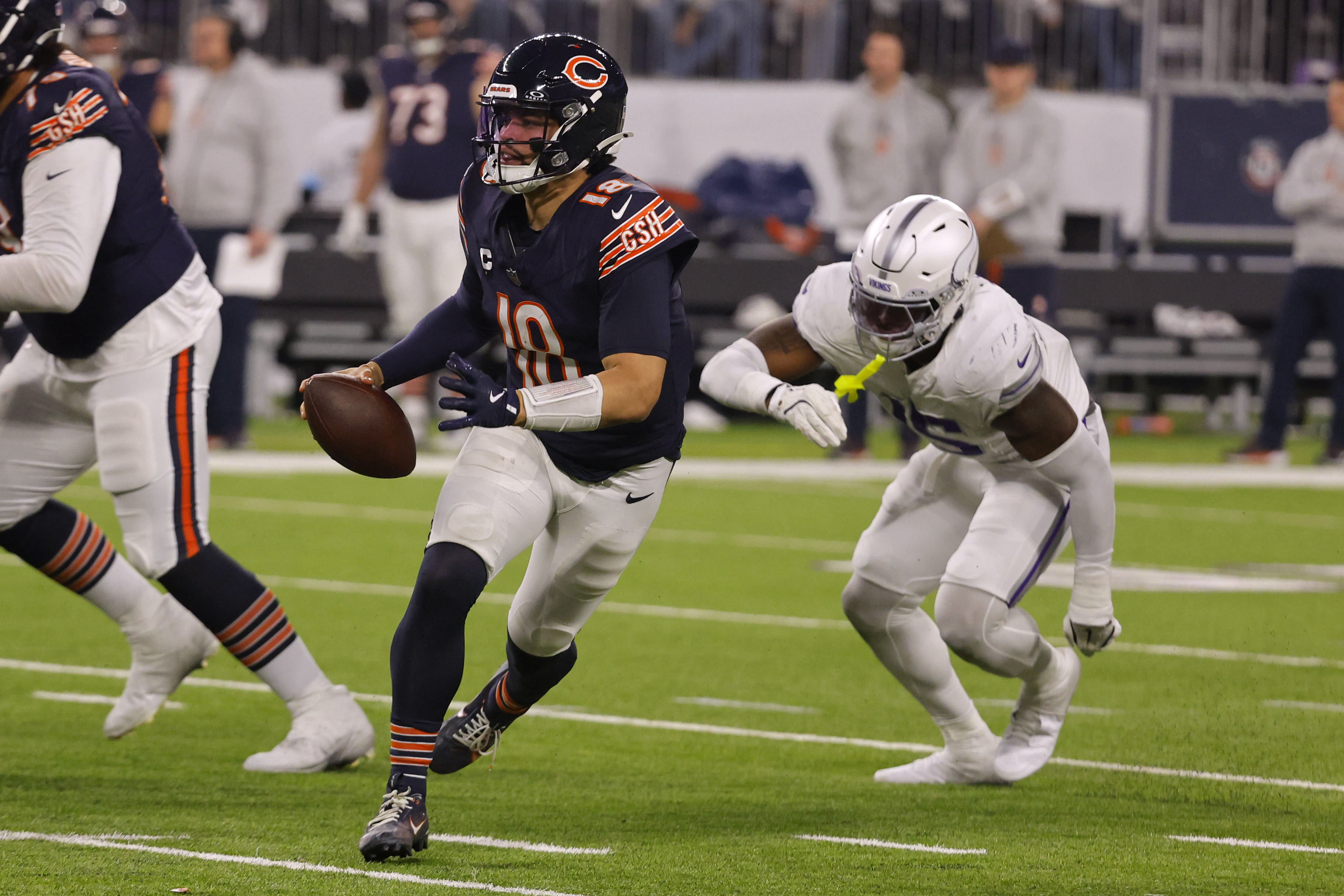 Chicago Bears quarterback Caleb Williams (18) runs from Minnesota Vikings linebacker Dallas Turner (15) during the second half of an NFL football game, Monday, Dec. 16, 2024, in Minneapolis. 