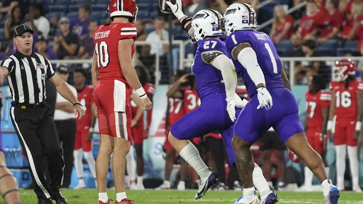 James Madison linebacker Jacob Dobbs (27) runs with the ball after recovering a Western Kentucky fumble during the first half of the Boca Raton Bowl NCAA college football game, Wednesday, Dec. 18, 2024, in Boca Raton, Fla.