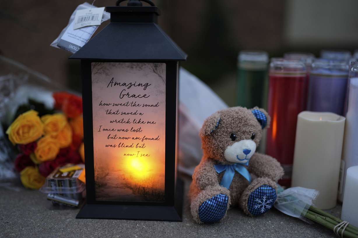 Flowers and candles are placed outside the Abundant Life Christian School Tuesday, in Madison, Wis., following a shooting on Monday.