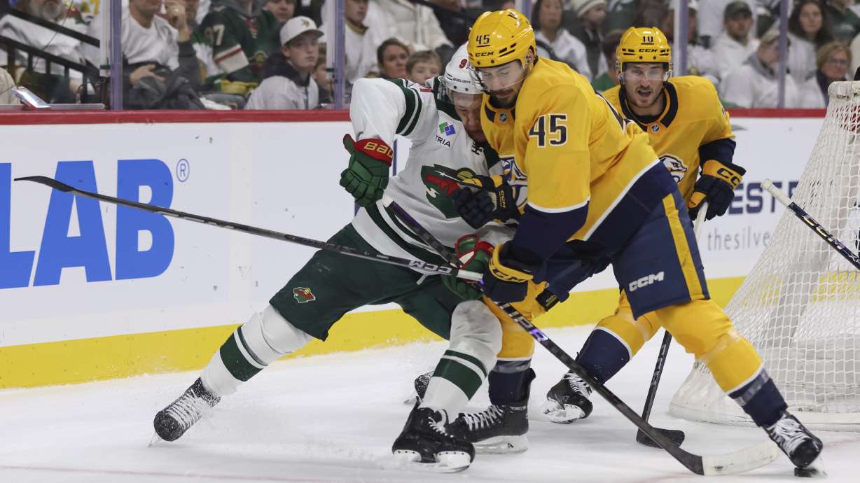 Nashville Predators defenseman Alexandre Carrier (45) hits Minnesota Wild left wing Kirill Kaprizov, left, during the first period of an NHL hockey game Saturday, Nov. 30, 2024, in St. Paul, Minn.