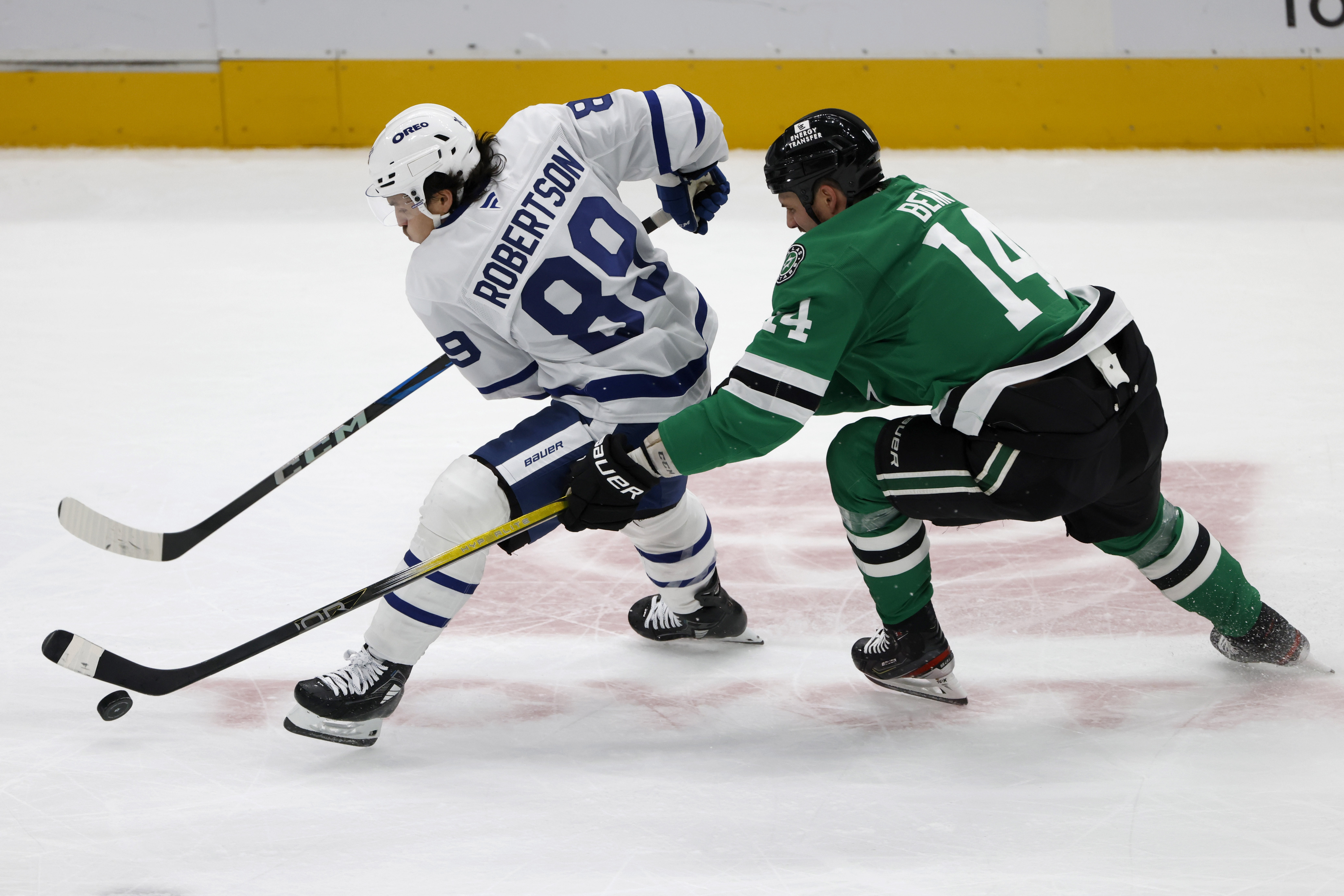 Dallas Stars left wing Jamie Benn (14) tries to get the puck from Toronto Maple Leafs left wing Nicholas Robertson (89) during the second period of an NHL hockey game in Dallas, Wednesday, Dec. 18, 2024.