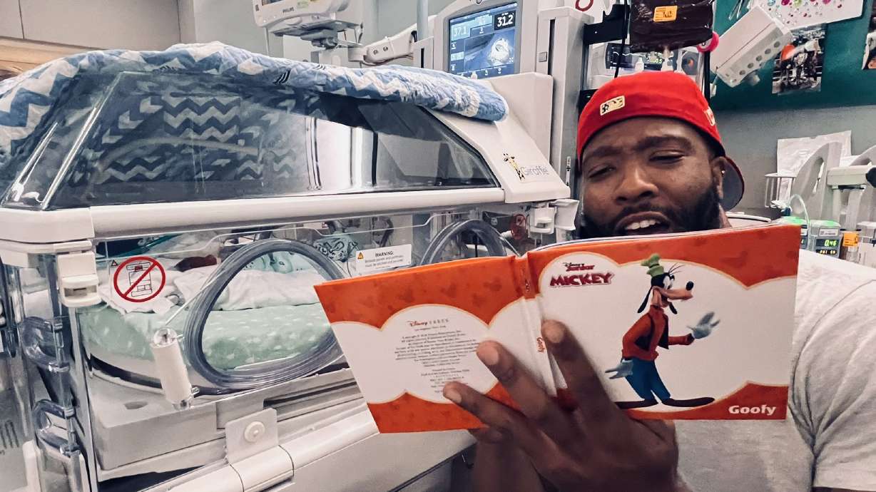 MLB pitcher Jay Jackson reads a children's book to his son, JR, while he recovers at the University of Utah Health neonatal intensive care unit in Salt Lake City in July 2023. Jackson authored a new book about lessons released this week