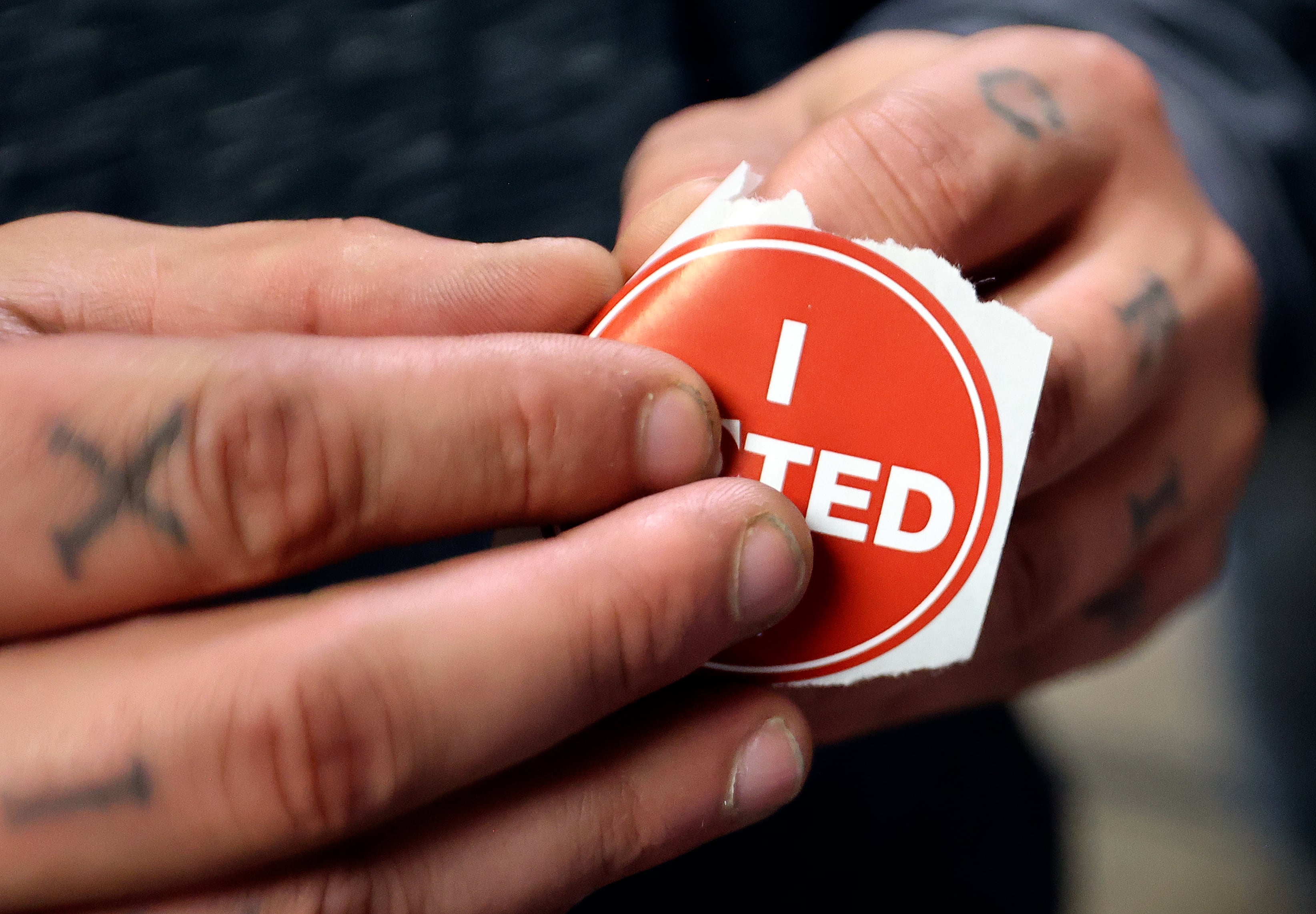 Chris Shibao puts his I VOTED sticker on after voting at the Salt Lake County Government Center in Salt Lake City on Nov. 5.